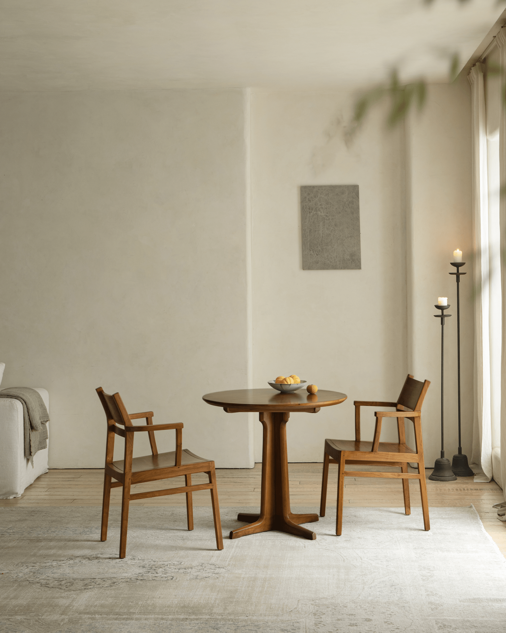 Hug Chair set in dining room with round table, wooden frame chair and leather seat, modern design, natural light