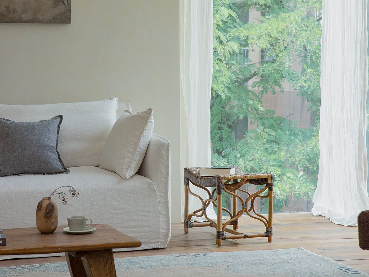 Melange Stool in a natural light living room setting with woven seat and manau rattan.