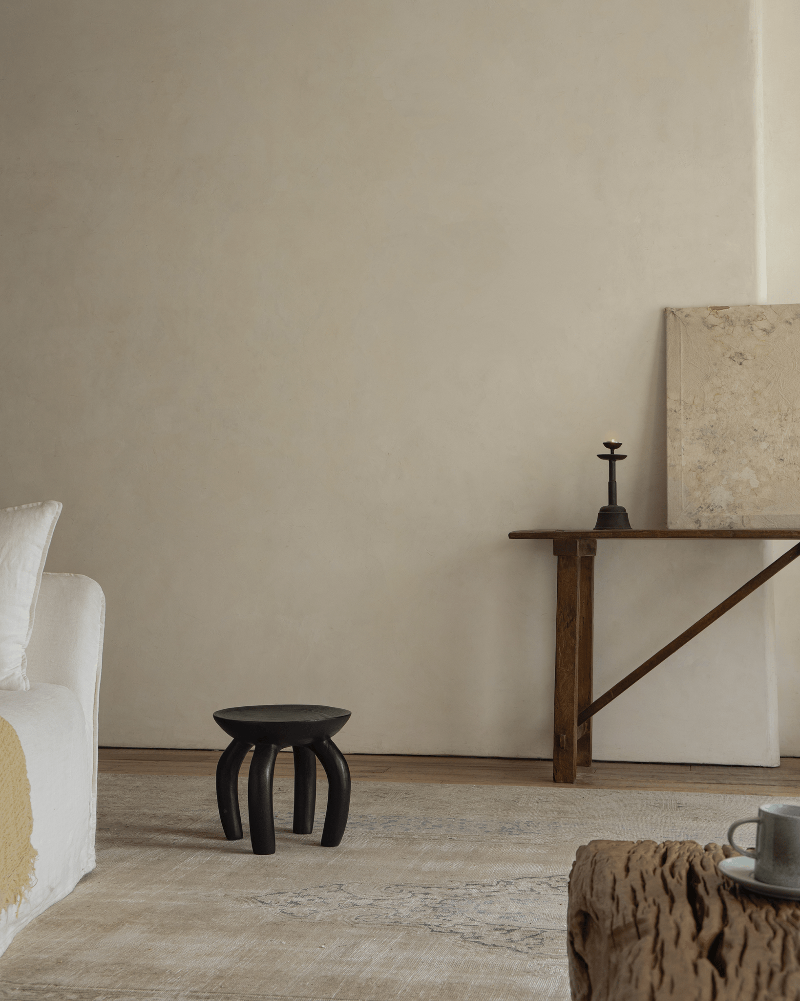 Black Jelly Stool in living room setting. Handcrafted solid wood, sustainable furniture, elegant design.