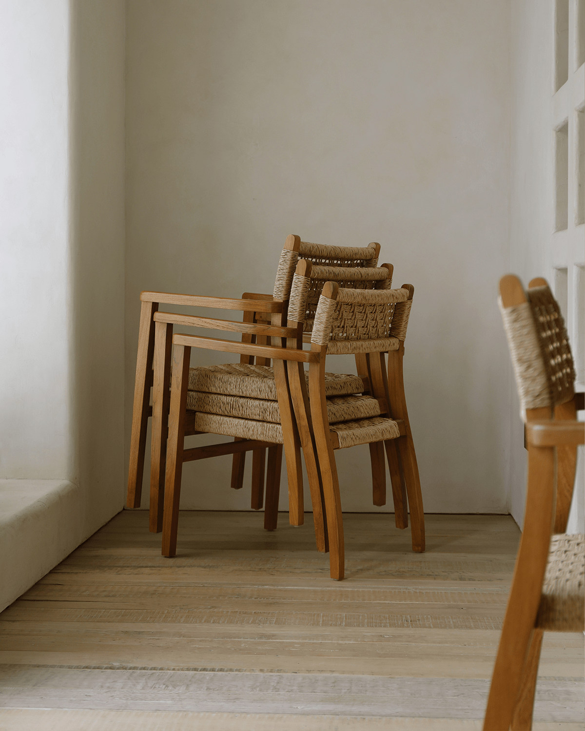 Stackable Reed Chair with teak frame and woven seat, ideal for dining or living spaces.