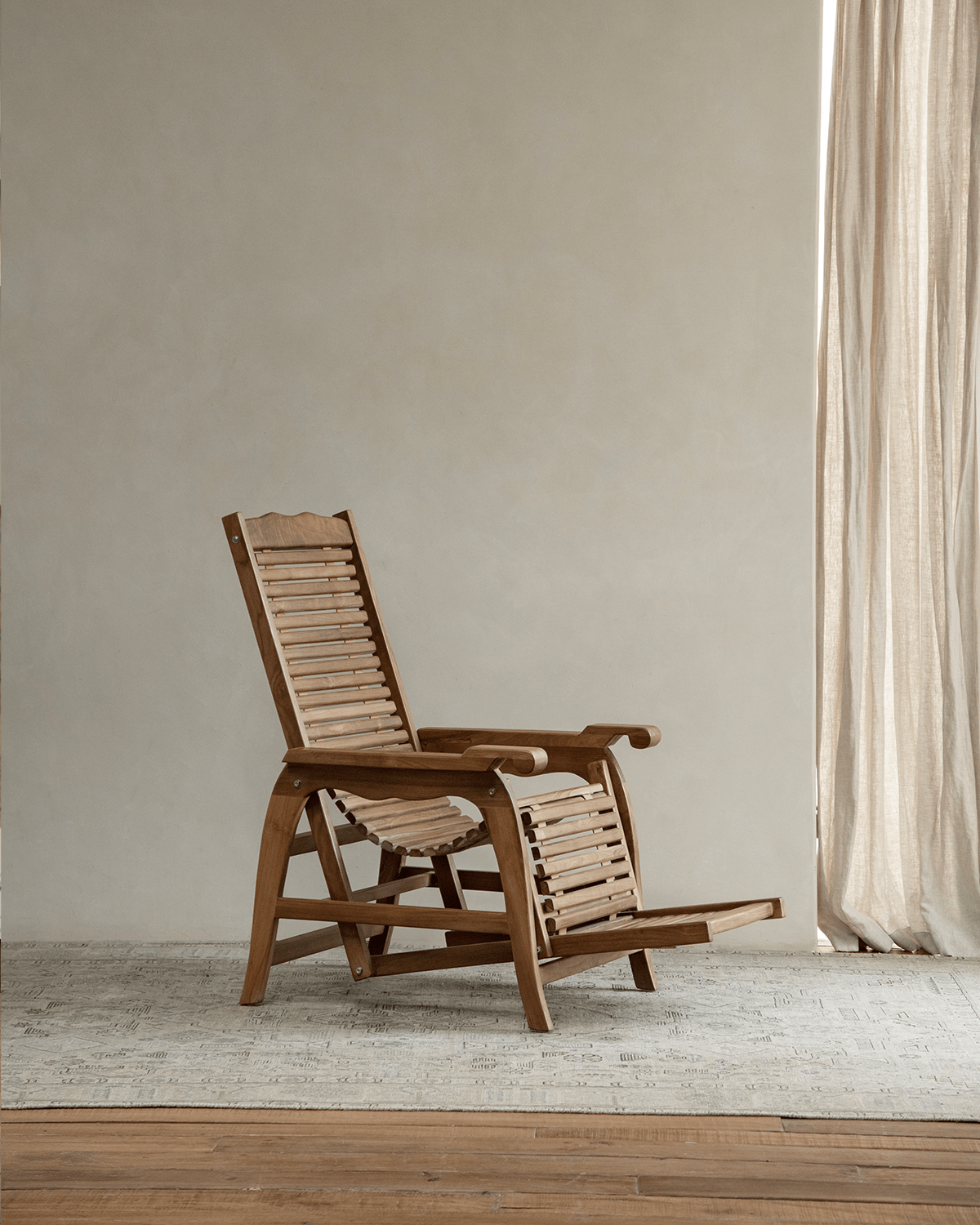 Teak Roller Chaise Lounge Chair indoors, ideal for relaxation and full-body support; adjustable tilt.