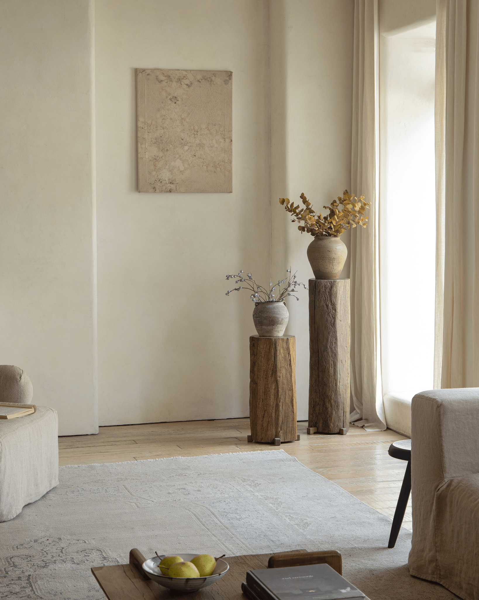 Rustic pedestal with dried flowers in organic interior, showcasing natural wood texture and timeless simplicity