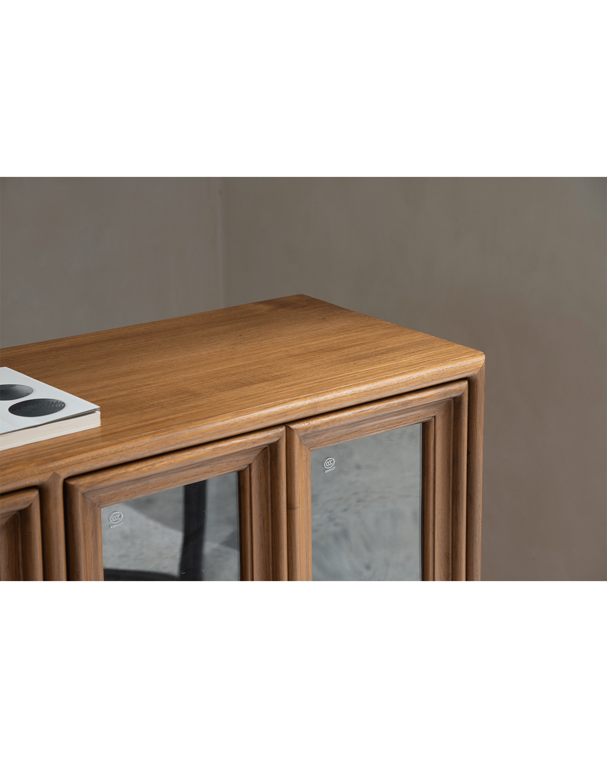 Teak wood stilt cabinet with glass doors detail. Elegant dining room storage and display solution.