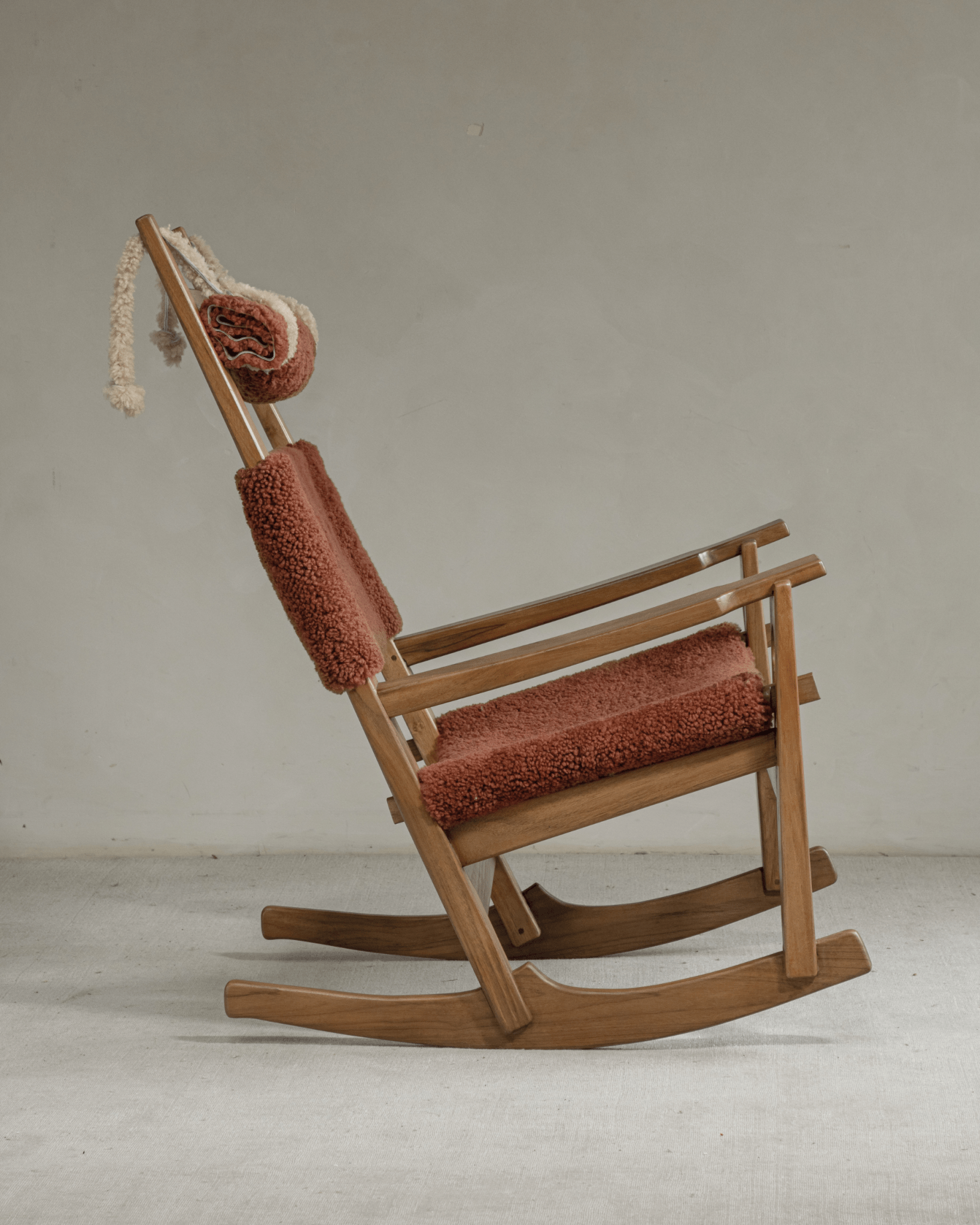 Hans Rocking Chair in plush terracotta shearling and solid teak wood frame, Danish design icon.