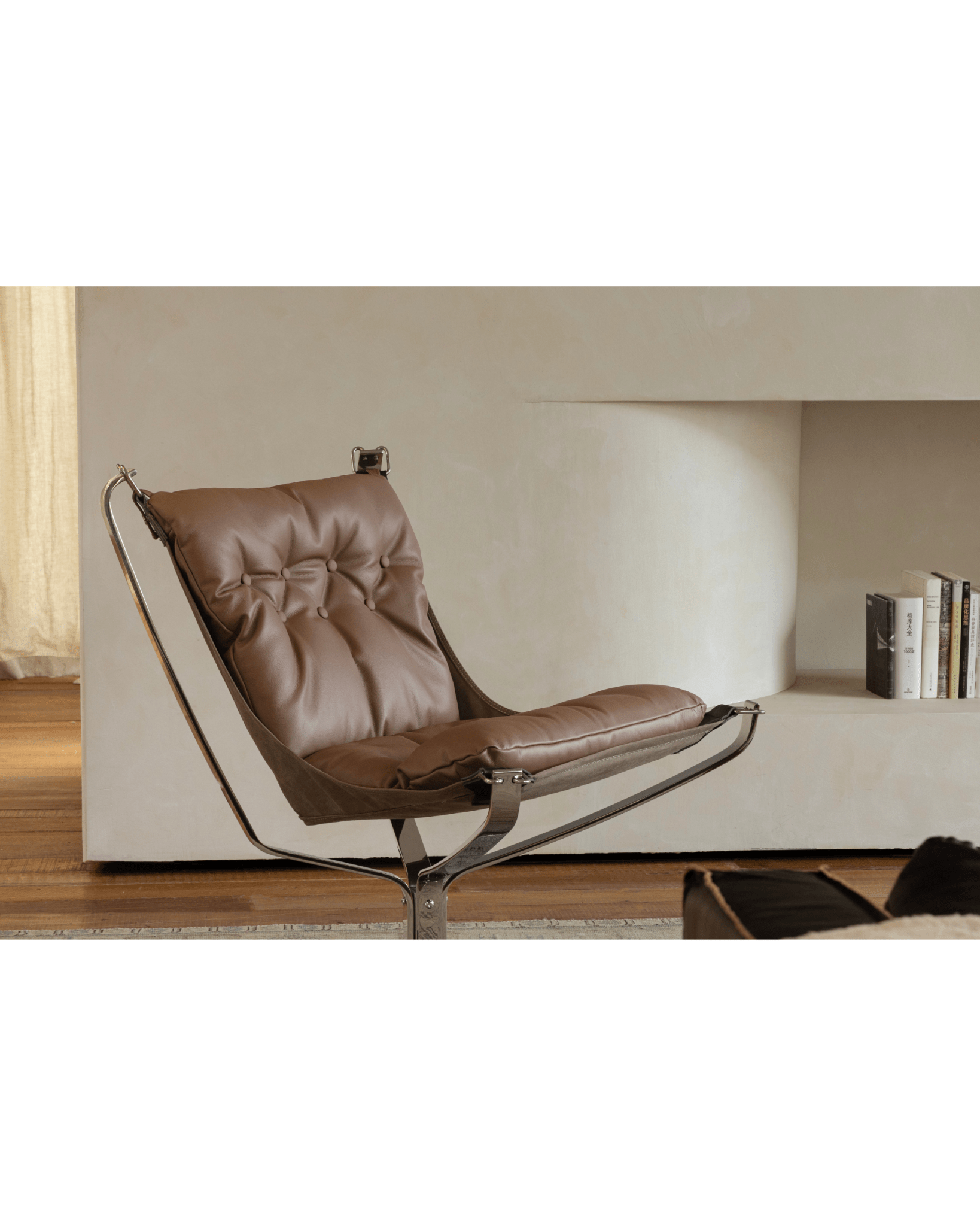 Brown leather Falcon Chair with stainless steel frame in a modern interior, Scandinavian design, premium comfort