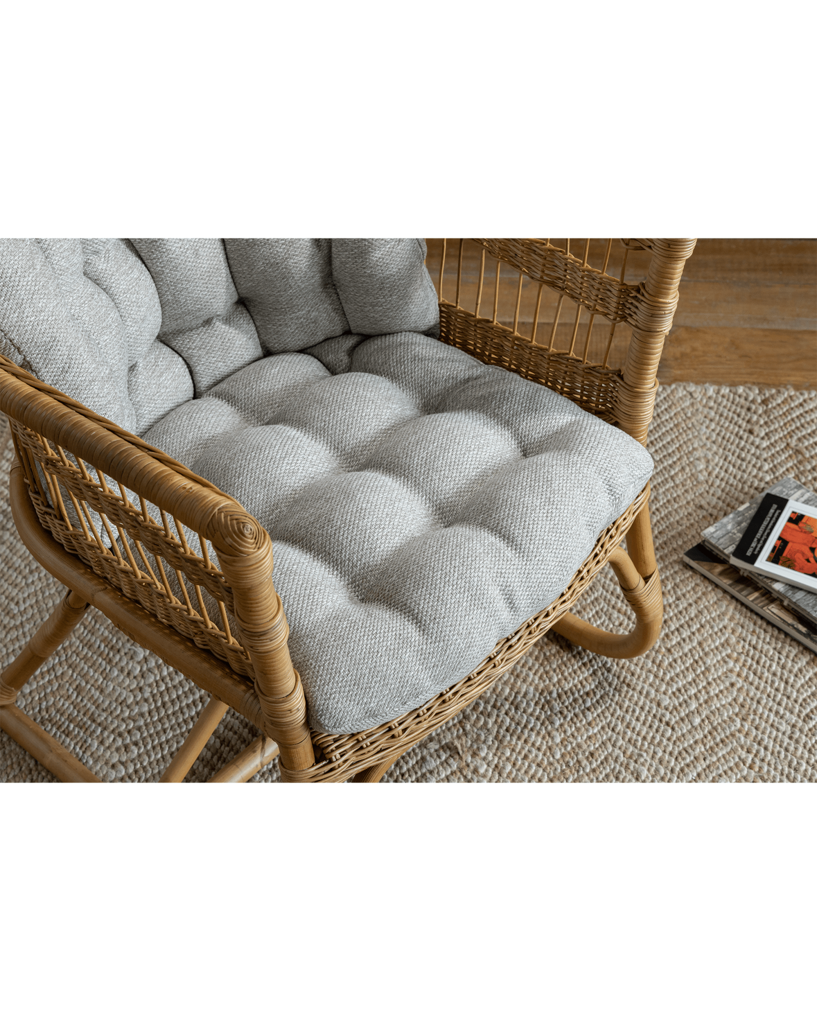 Helian Rattan Chair with gray cushion and natural frame, in a cozy interior setting.
