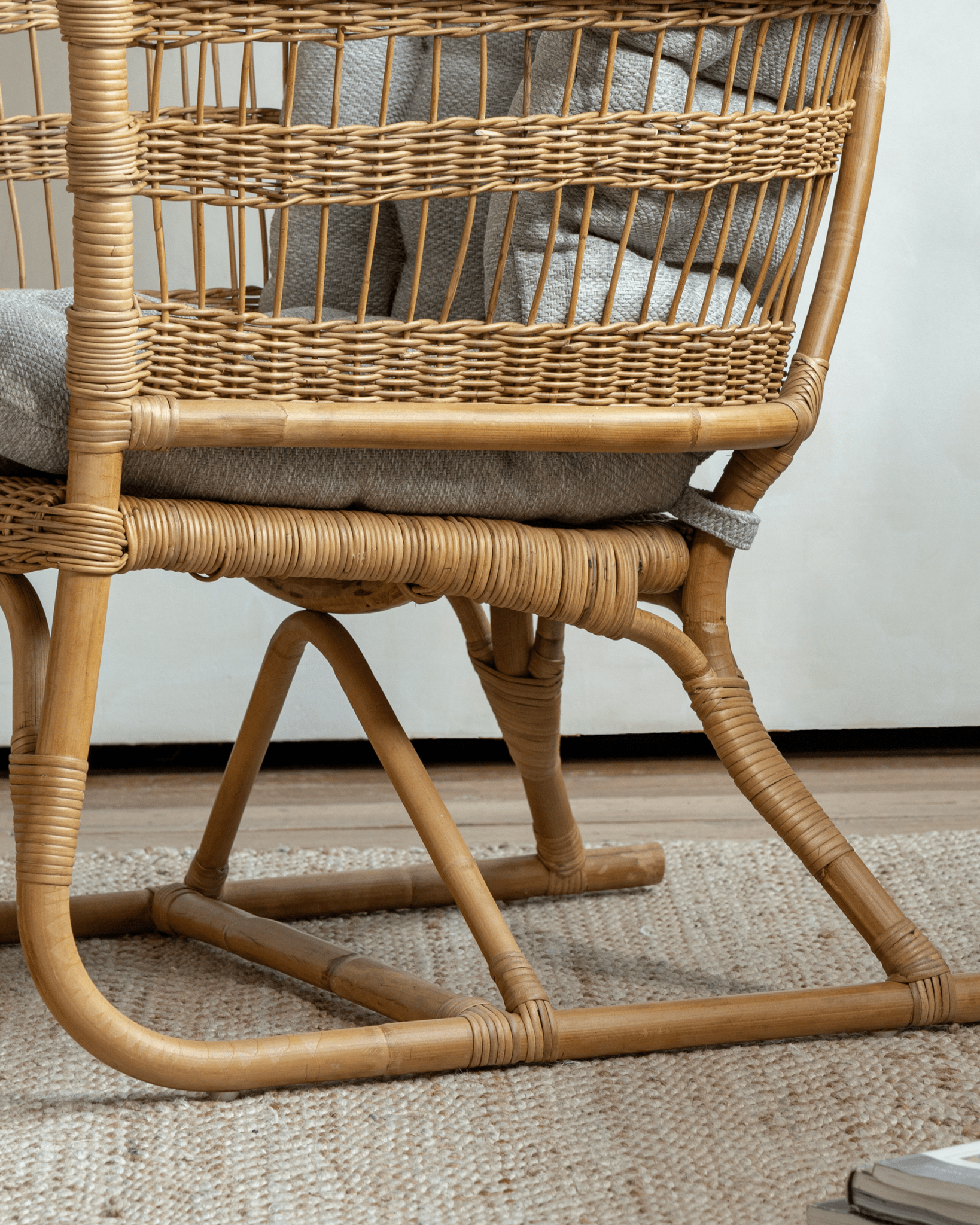 Helian Rattan Chair detail: natural rattan frame and gray silk cushion, handcrafted design.