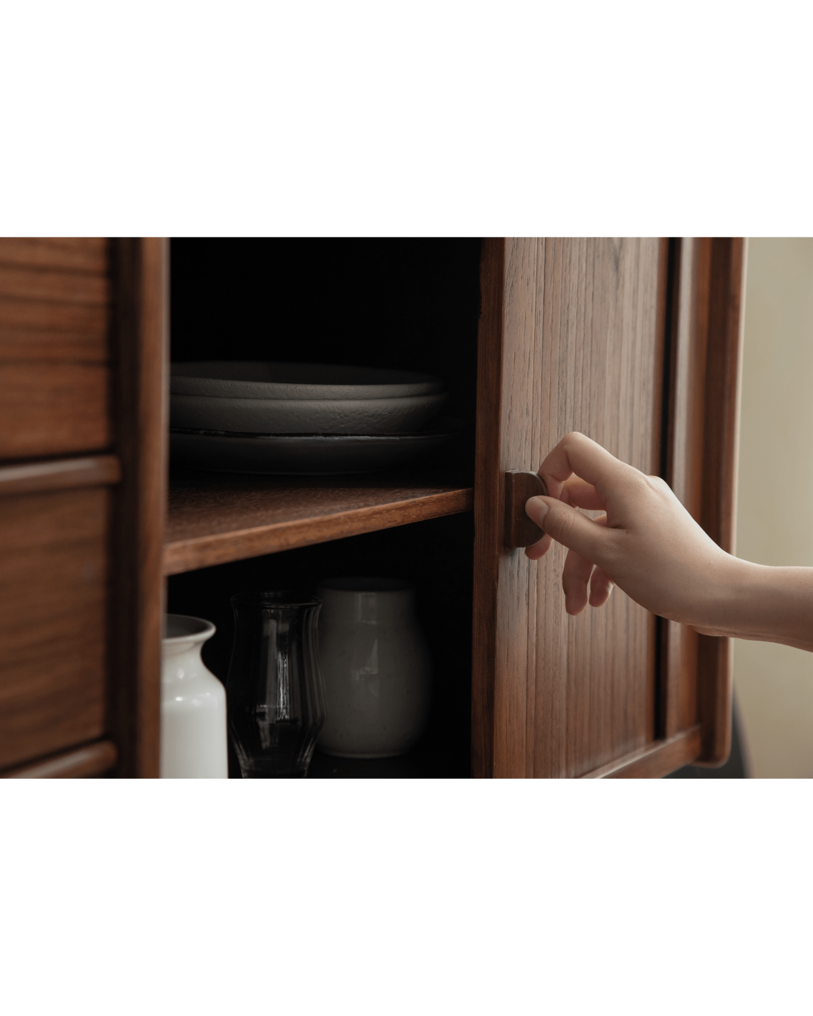 Ibu Teak Sideboard: hand opening tambour door revealing shelves with plates & vases.