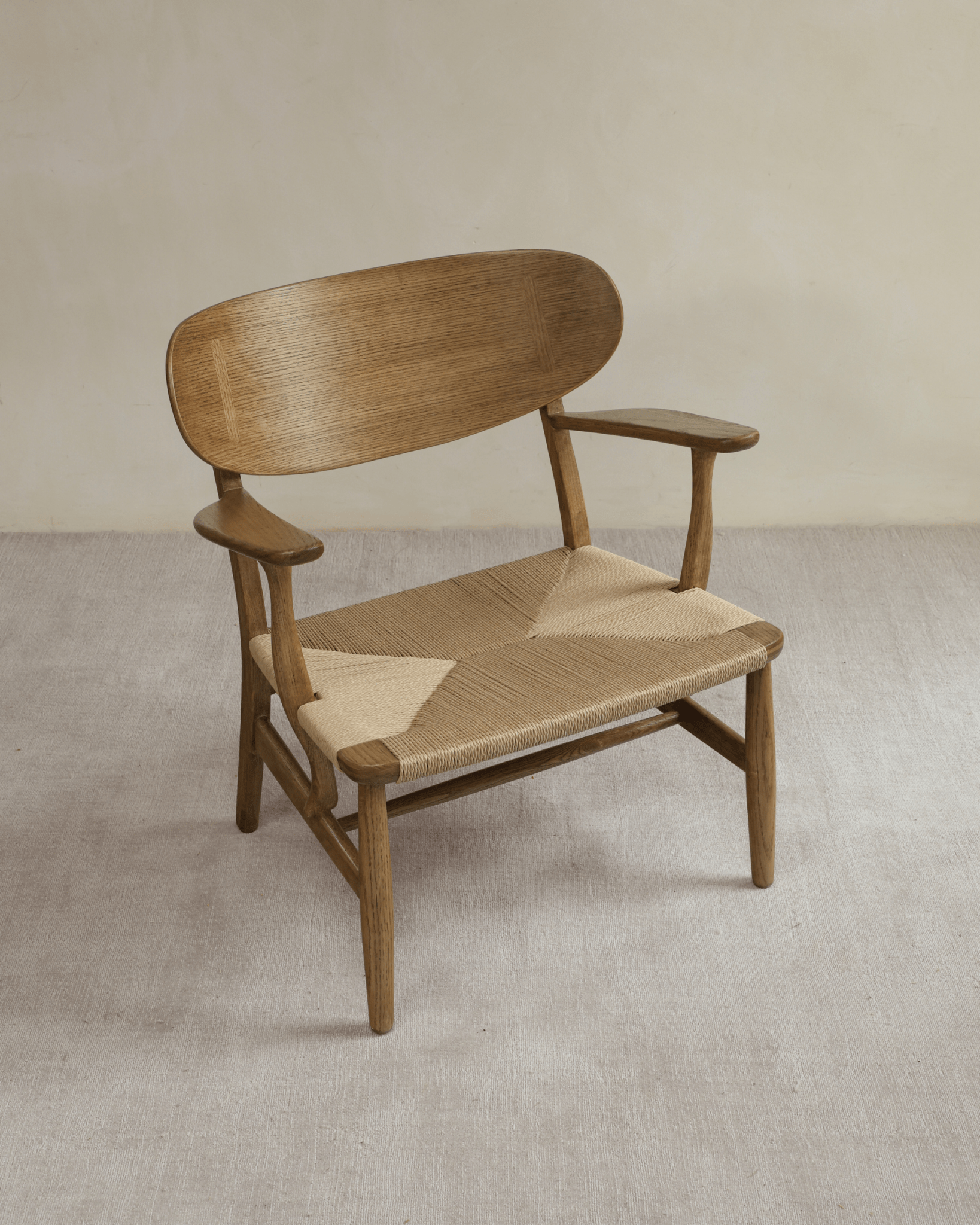 CH22 Lounge Chair in oak with woven paper cord seat. Scandinavian design for modern interiors.