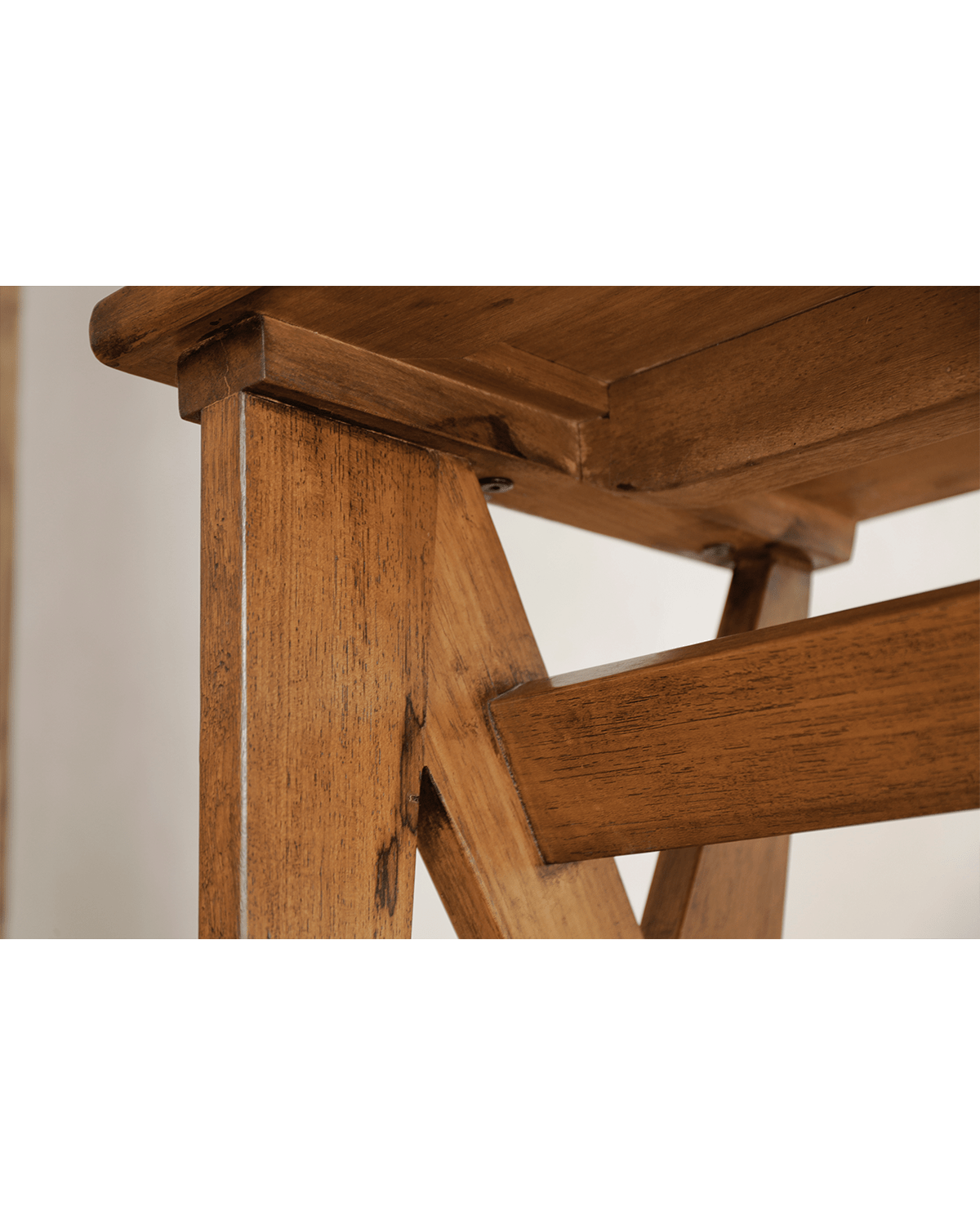 Teak writing desk detail, highlighting wood grain and craftsmanship. Close up view of the leg and support structure.
