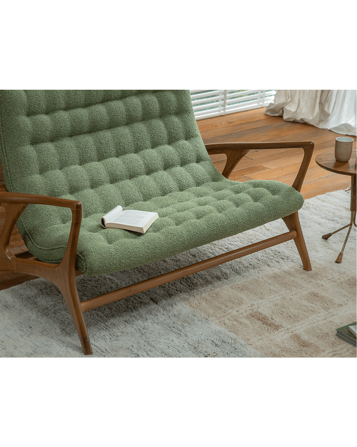 Kagan Loveseat in Green Bouclé Upholstery with Teak Frame. Mid-century modern design in cozy living room setting.