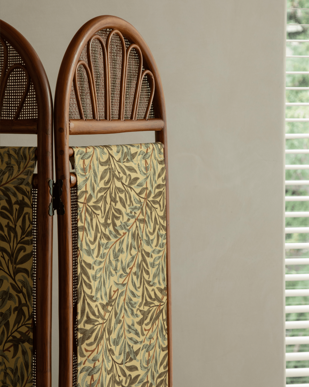 GeTan room divider: Natural rattan frame, arched woven top, detachable beige fabric with green willow leaf pattern.