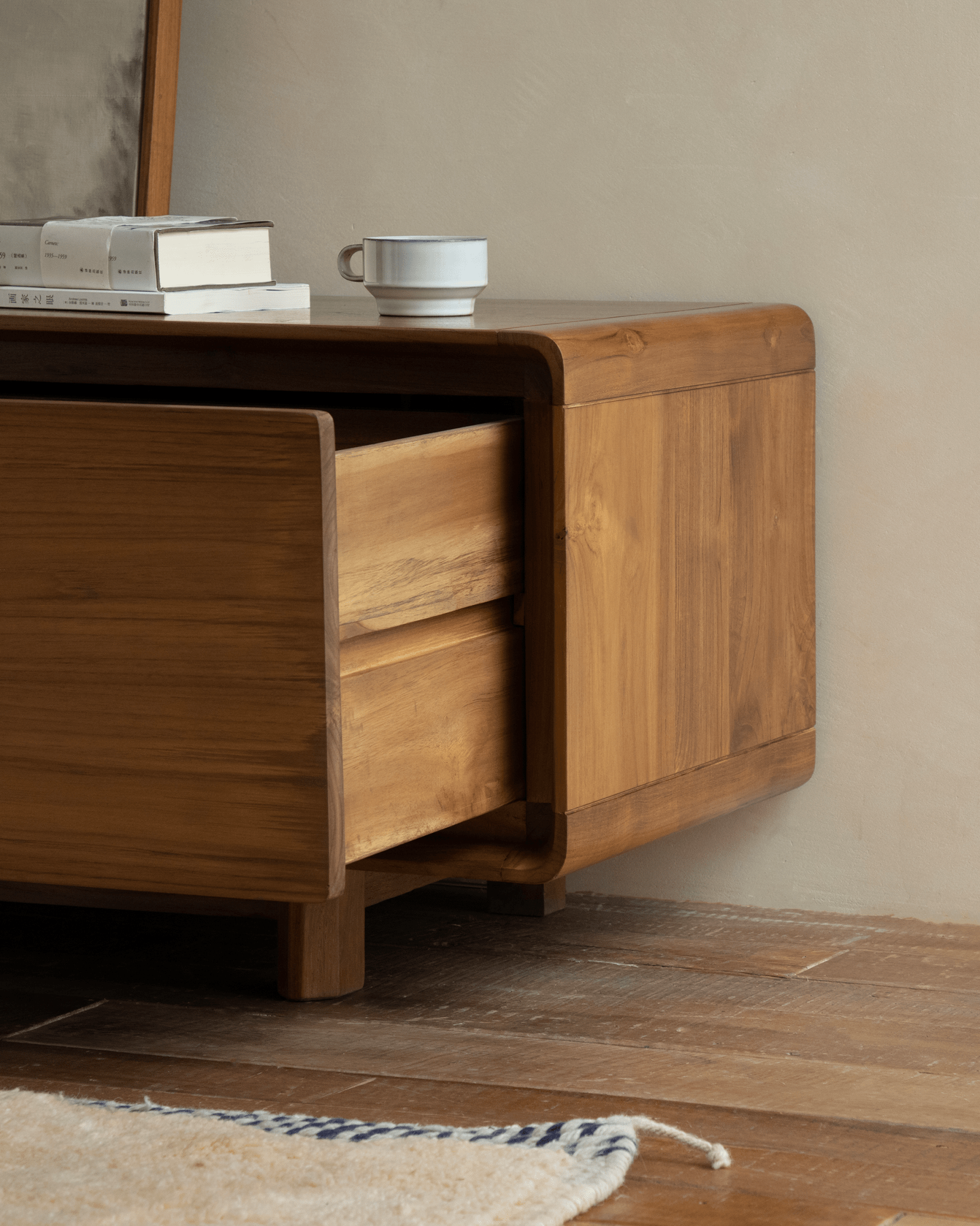 NO.34 Media Console with open drawer, displaying wooden construction, a coffee cup, books and a small rug on wooden flooring.
