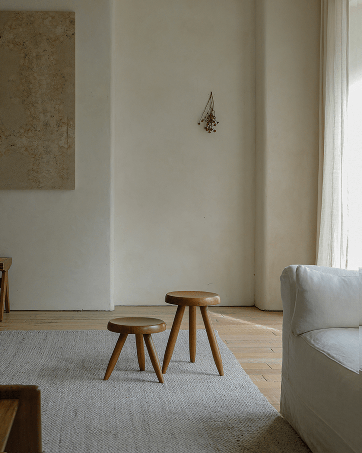 Two French stools with natural wood finish in a modern living room setting, perfect for home decor.