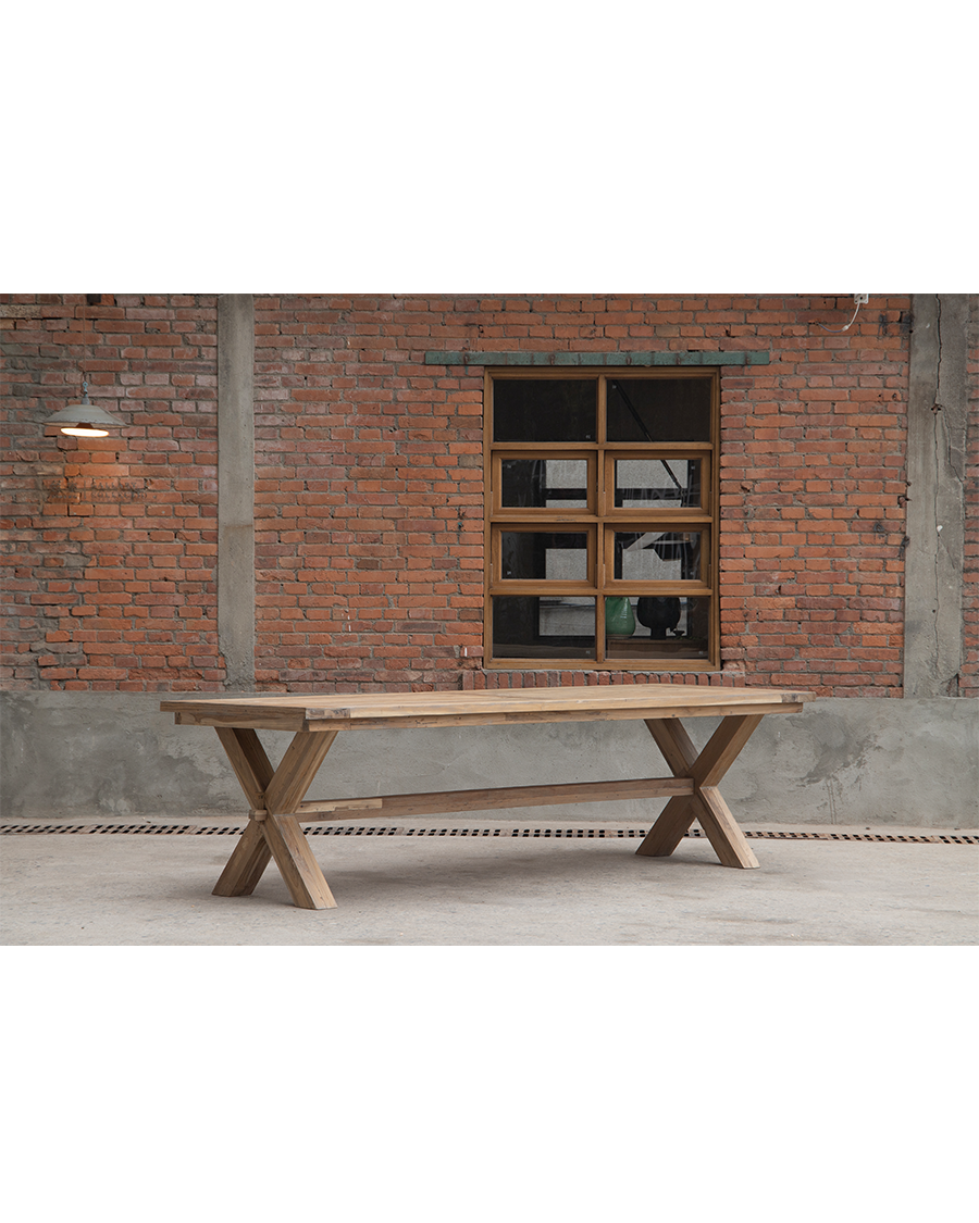 Outdoor teak farm dining table with distinctive X-shaped legs.