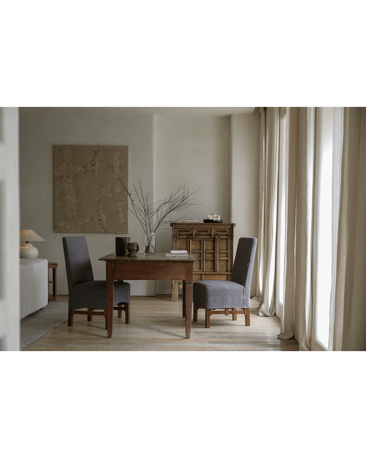 Feast Dining Chair with dark grey linen slipcovers in a modern dining room setting