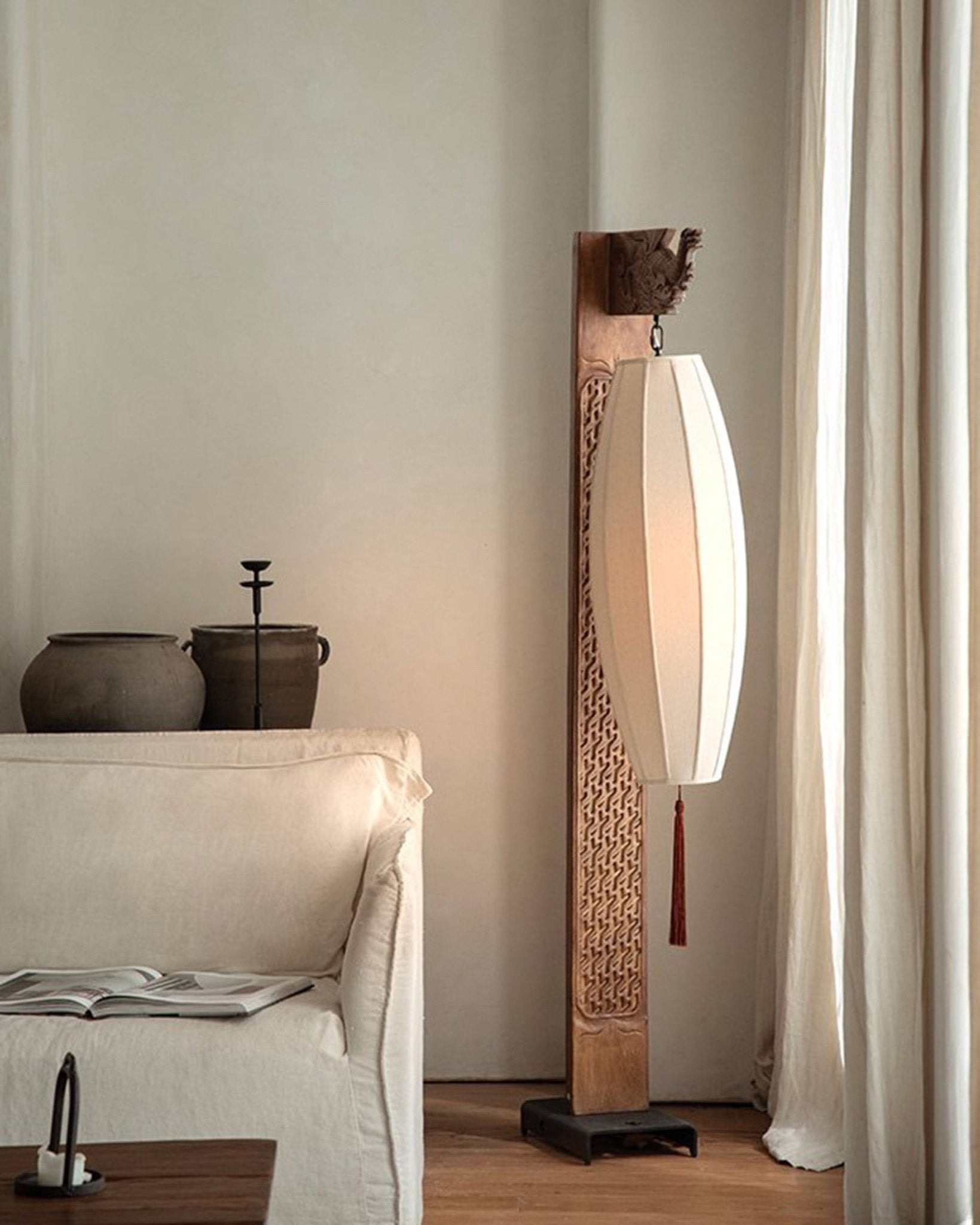 Chinese floor lamp with fabric shade, intricate carved wooden frame, and tassel detail. Oriental home decor.