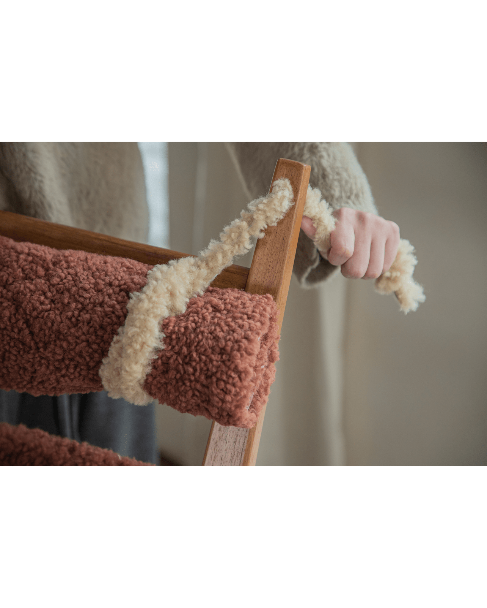 Hans Rocking Chair with plush caramel shearling upholstery and cream trim on teak frame.