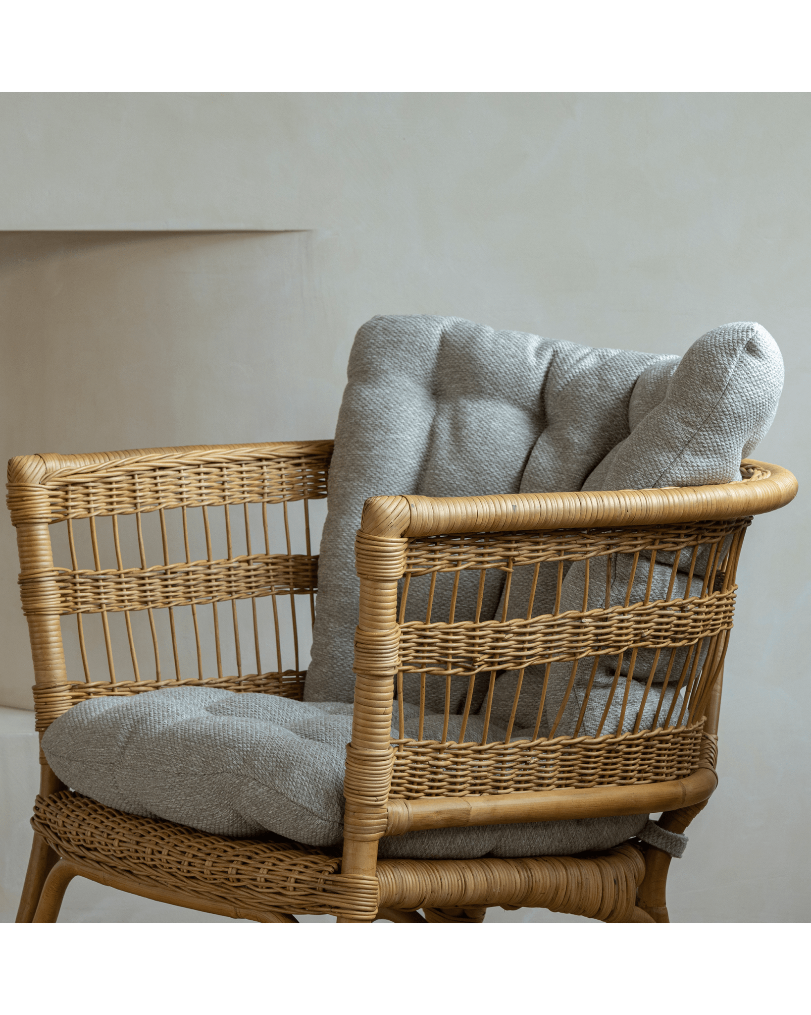 Helian Rattan Chair with gray cushion and natural rattan frame, a cozy and stylish design