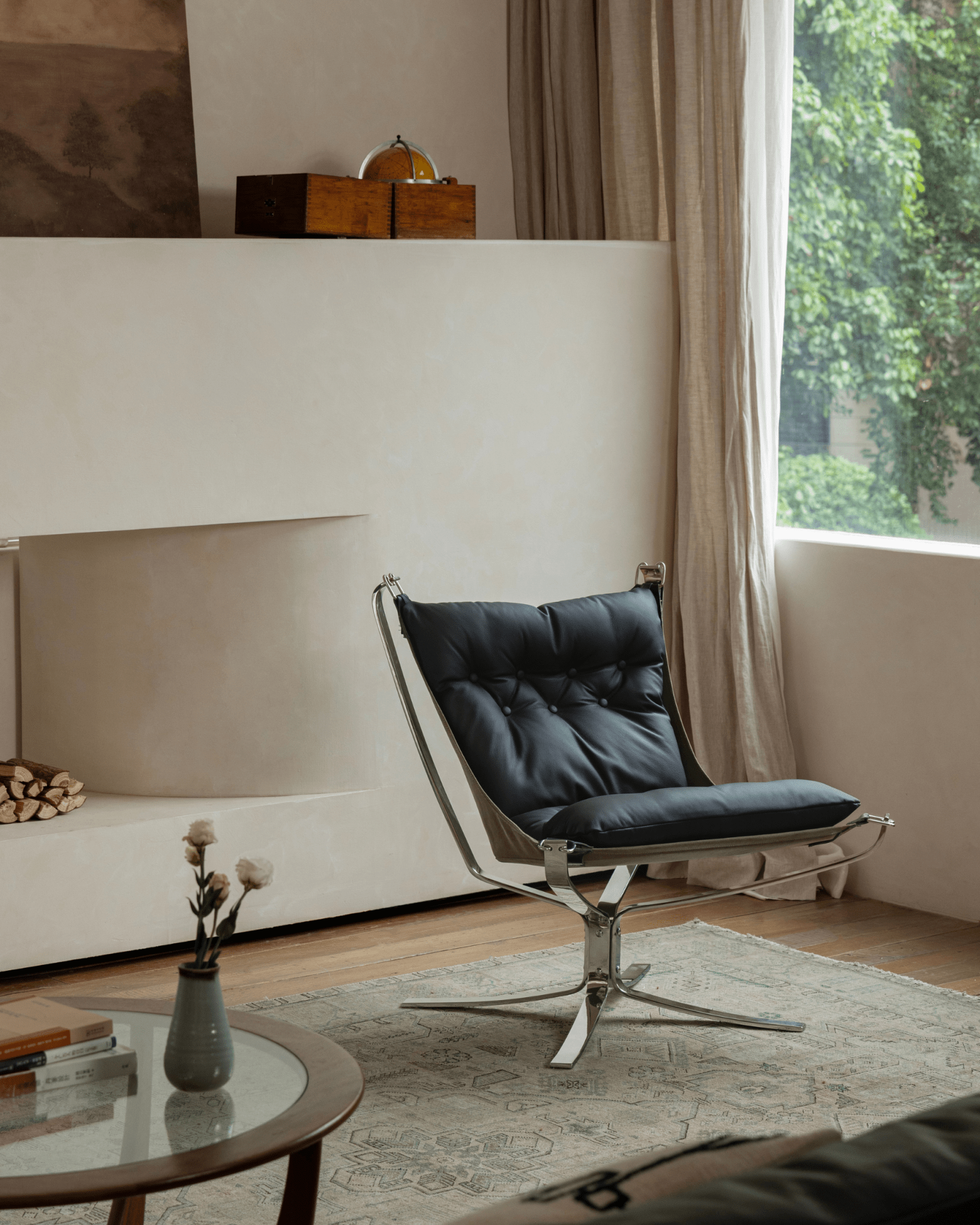 Black leather Falcon Chair in a Scandinavian-inspired living room setting, stainless steel frame, premium comfort