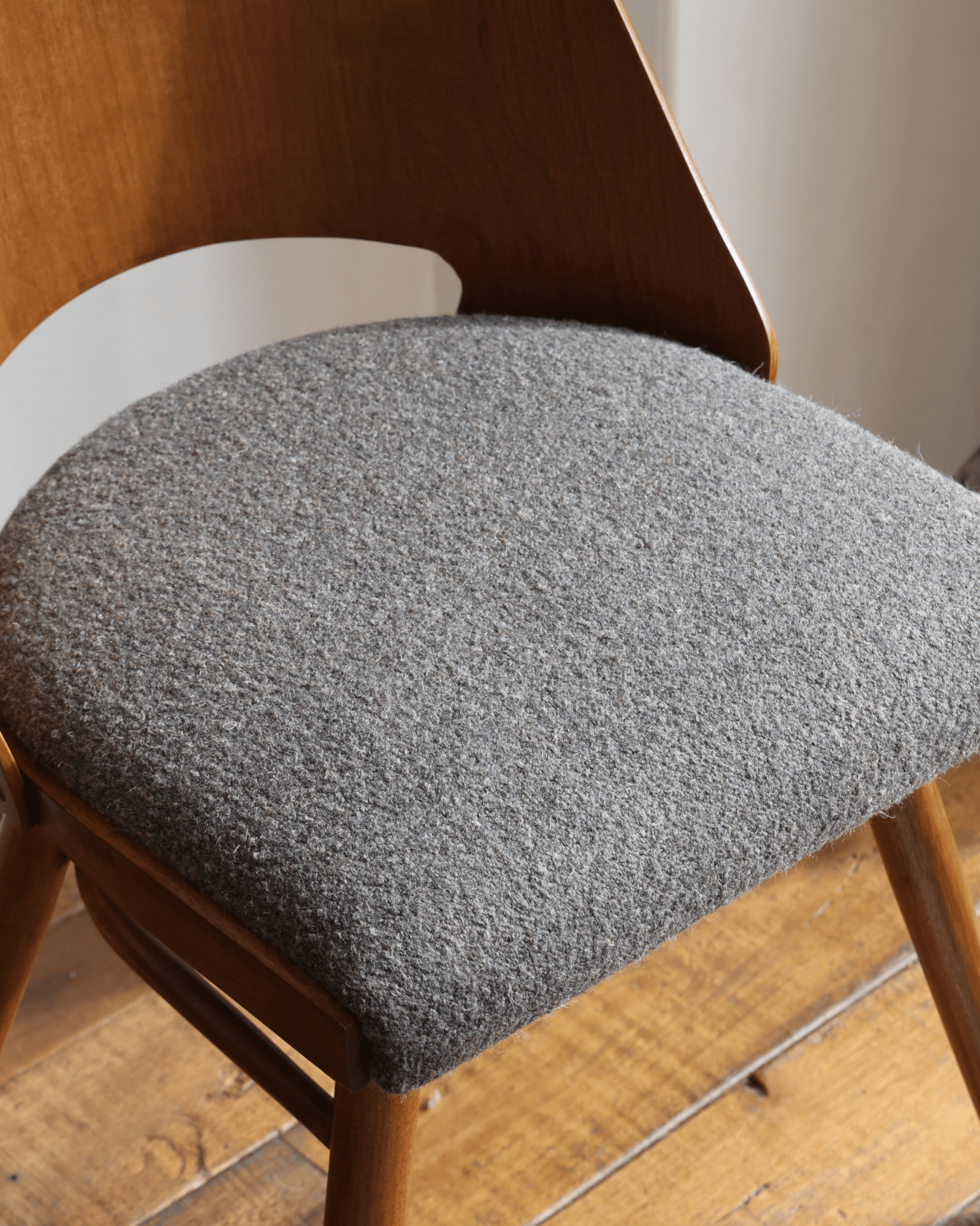 Shell Chair with coffee grey loop fabric seat and teak wood frame, mid-century modern design, wooden flooring