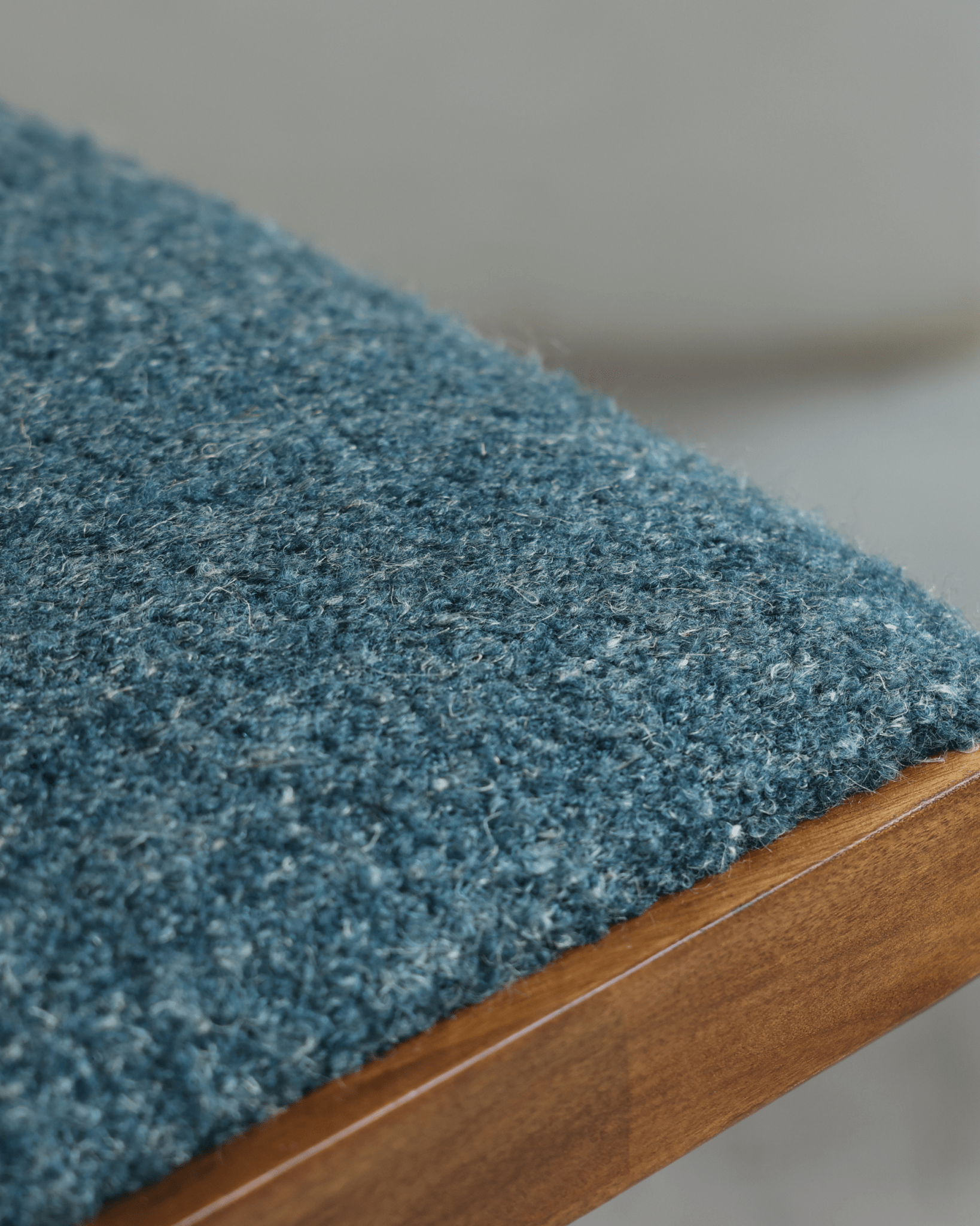 Shell Chair detail: blue loop fabric seat and teak wood frame, mid-century modern design