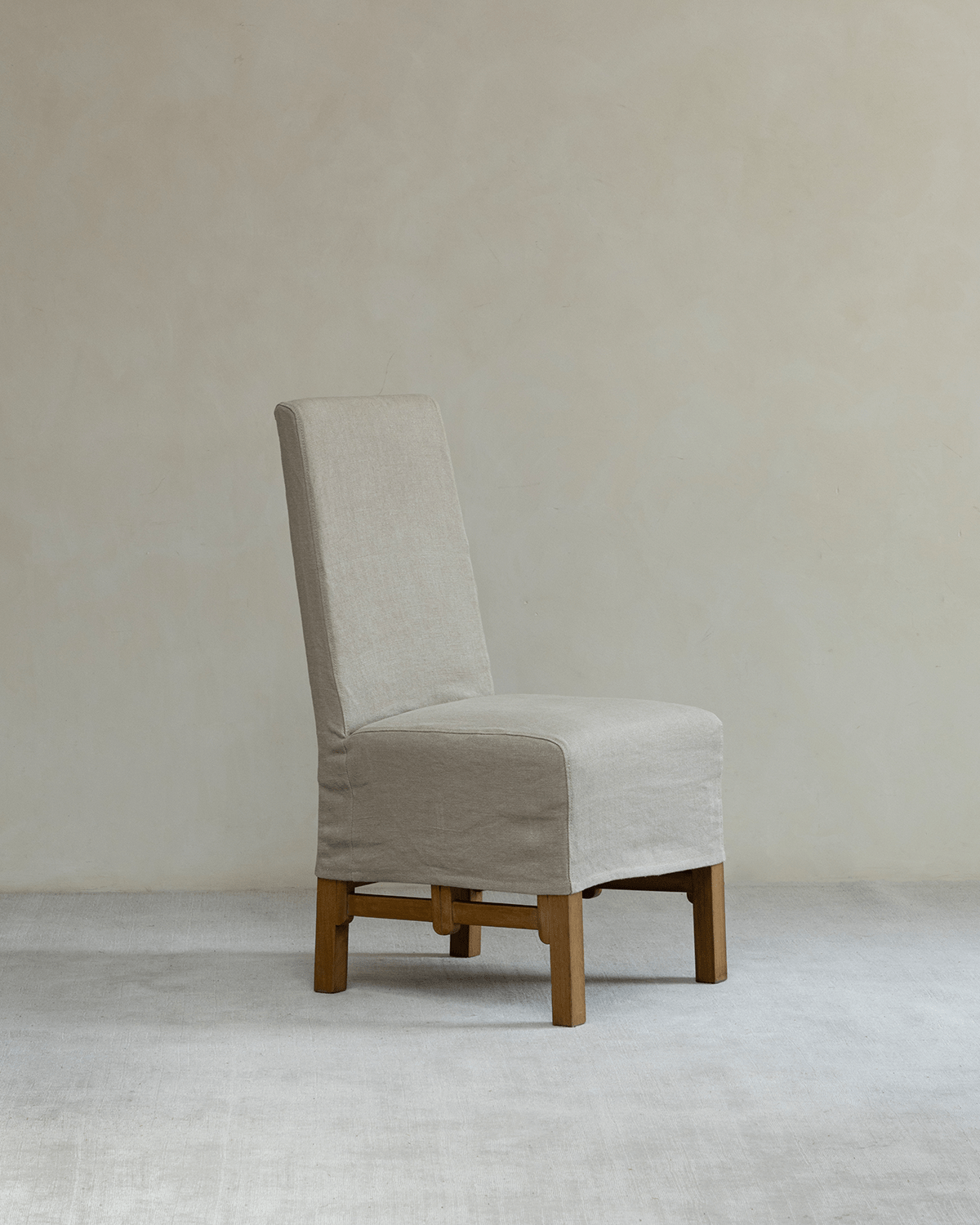 Feast Dining Chair with light beige linen slipcover and wooden frame, perfect for modern dining