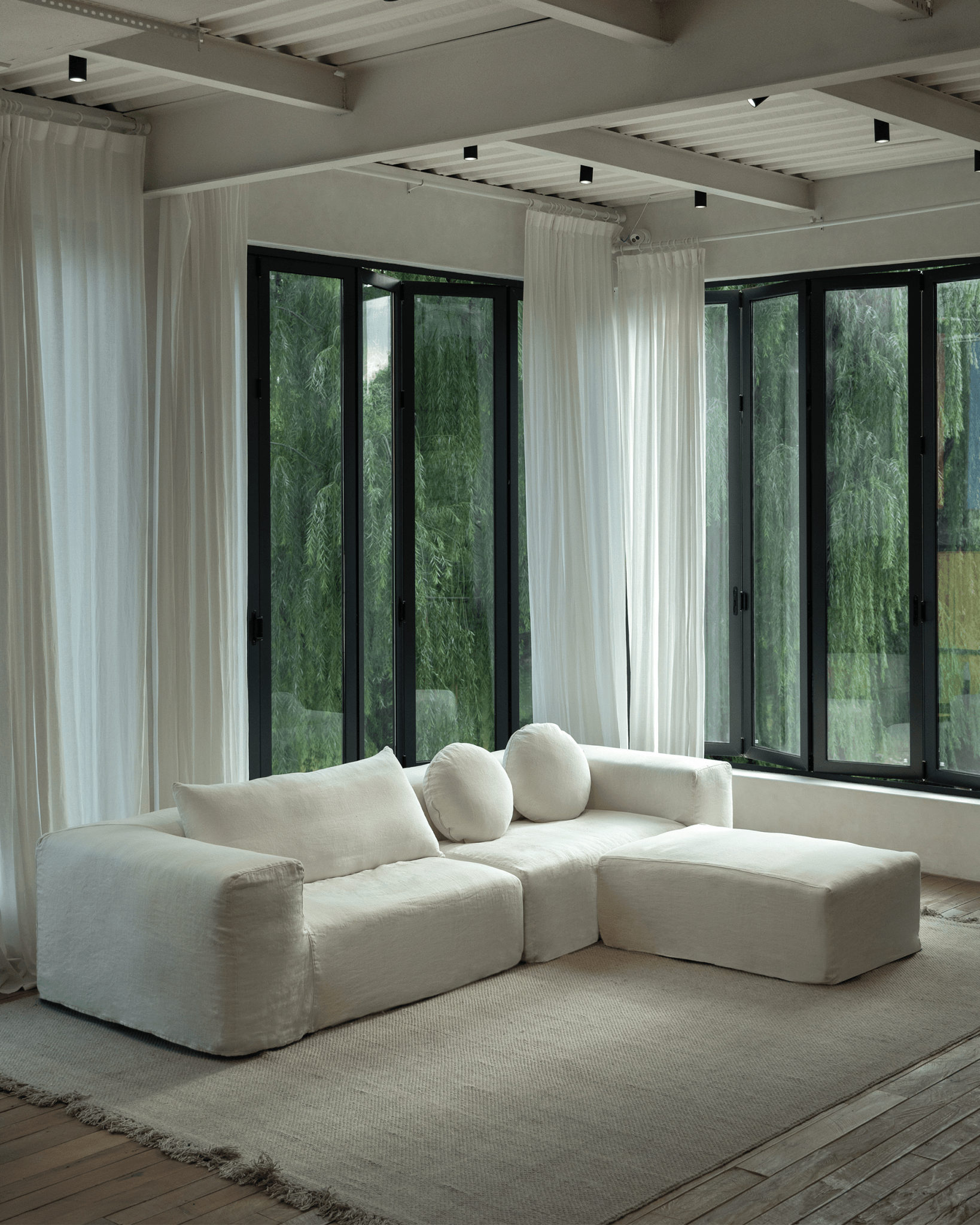Doma Sectional Sofa in White Linen. Wide armrests for comfort in a bright, airy living space with modular design.