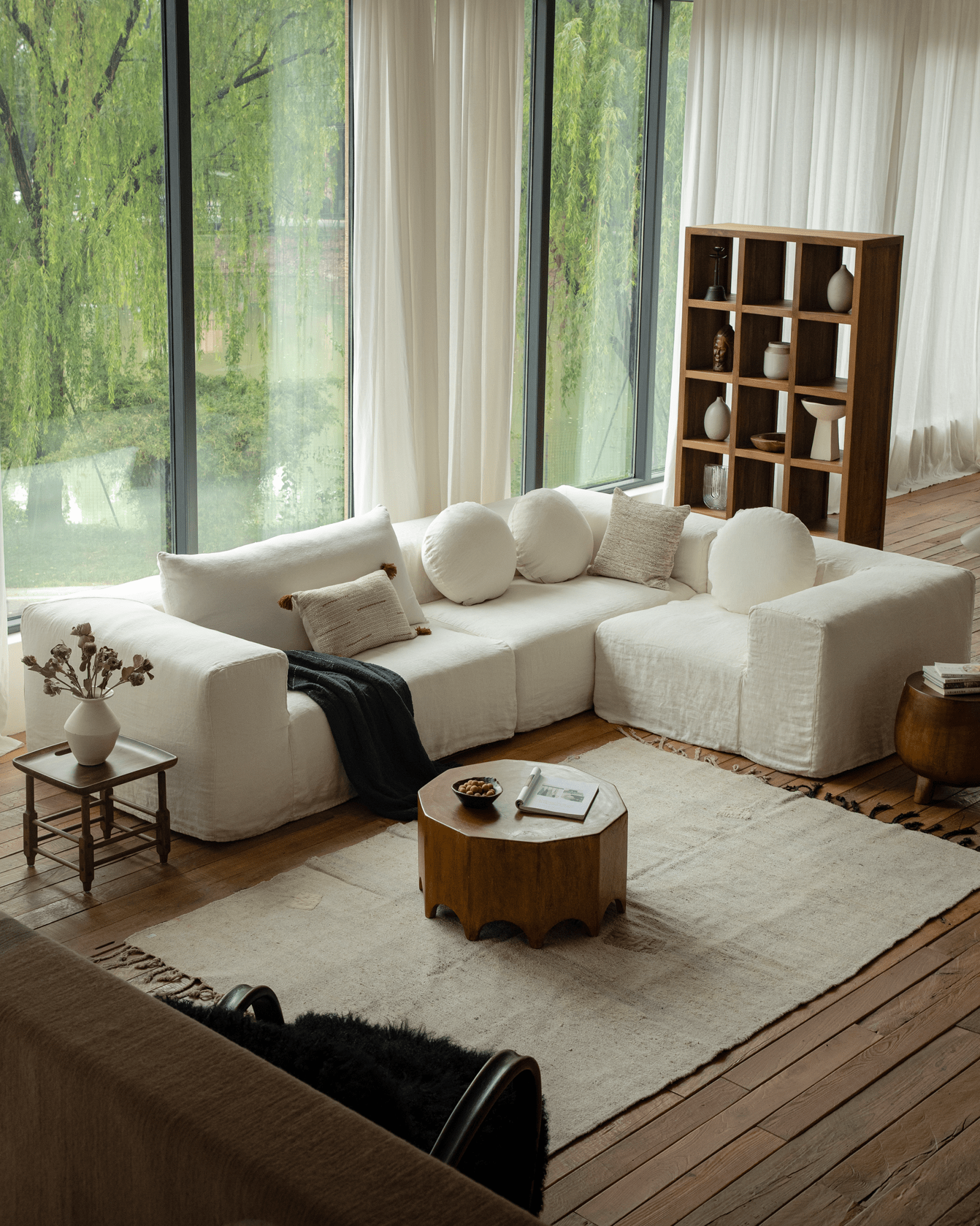 Decagon side table in a modern living room with a white sofa and a large window