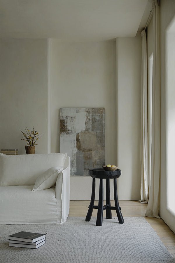 Basin Side Table in a modern living room with black wooden stool and minimalist decor.