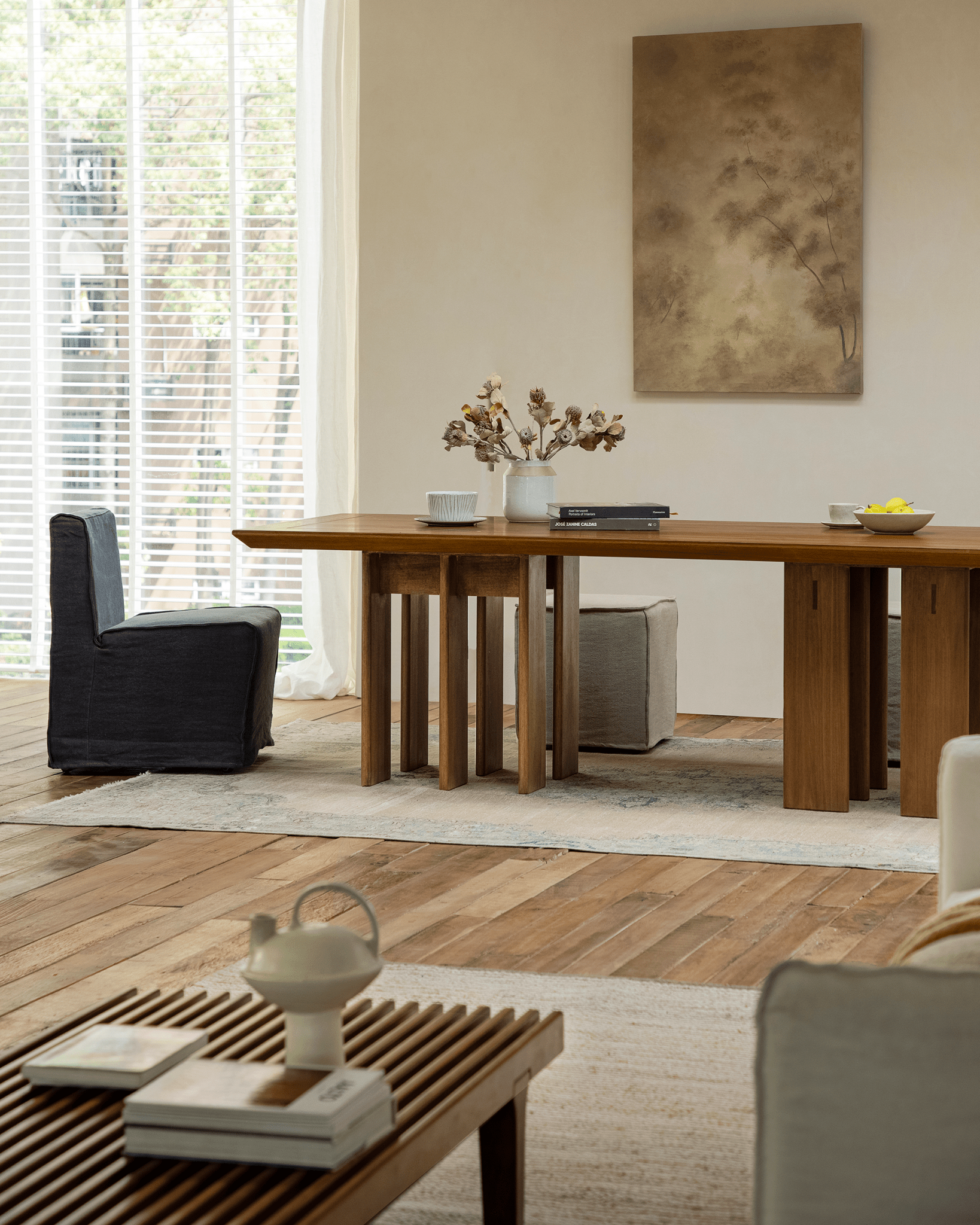 Titan Teak Dining Table in modern room. Teak wood, multi-leg design. Matching chairs and natural light.