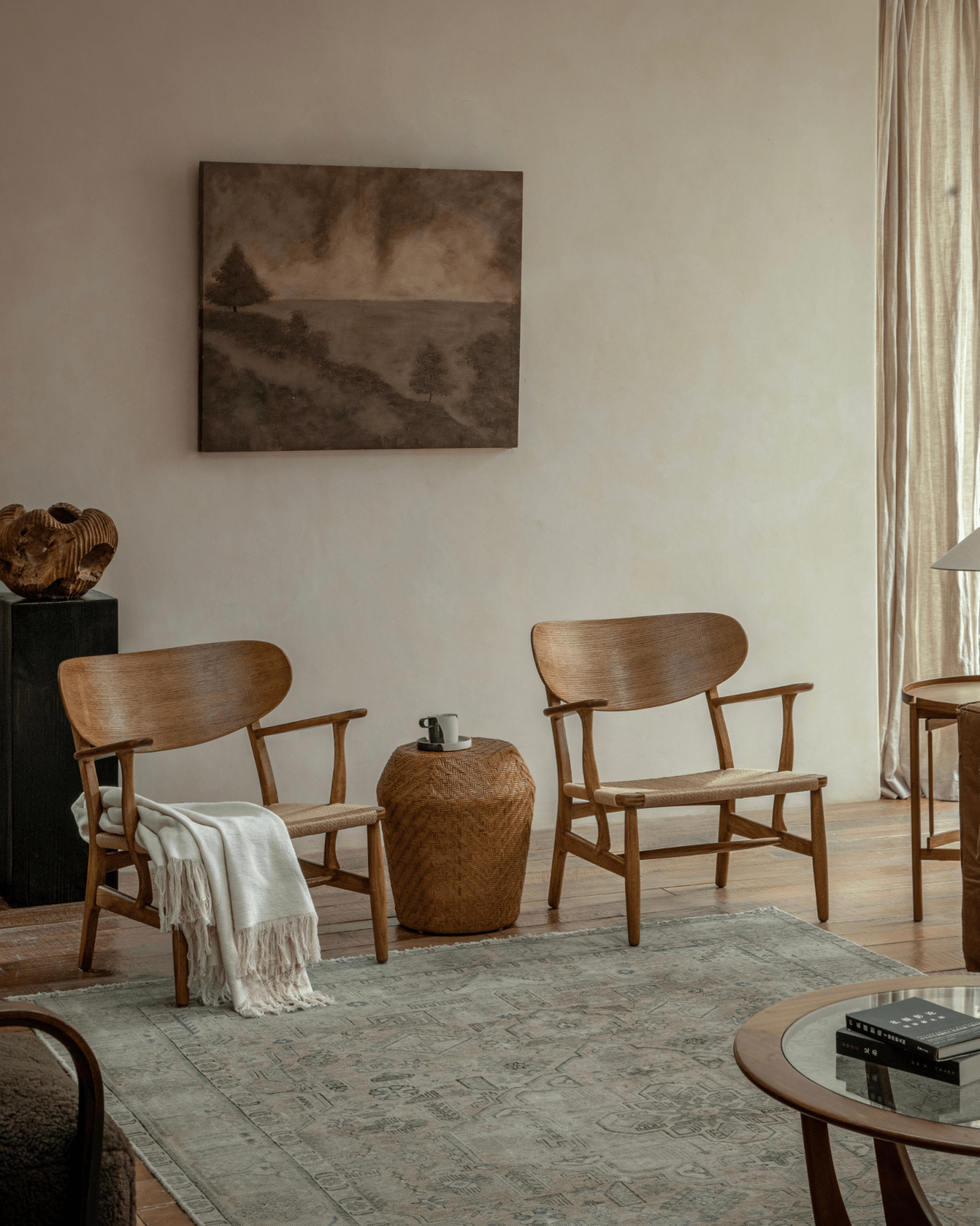 CH22 Lounge Chairs in oak with paper cord seats in a Scandinavian living room setting, enhancing modern interior design.