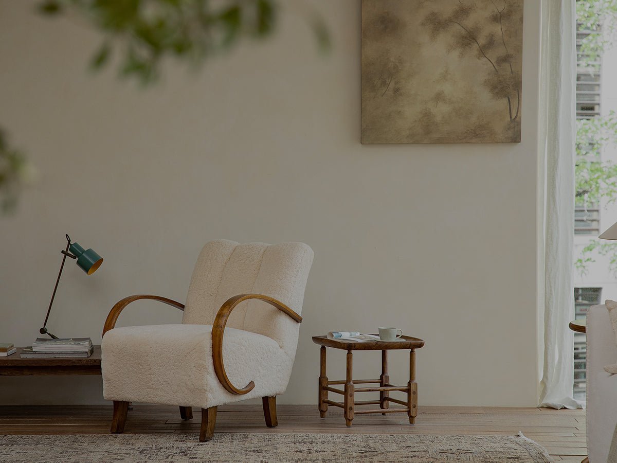 Cream armchair with wooden arms in a modern living room interior.