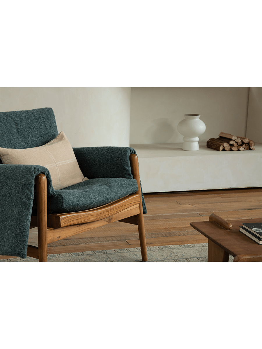 Teak wood garden lounge chair with dark teal cushion and throw, indoor comfort, wooden frame, stylish interior