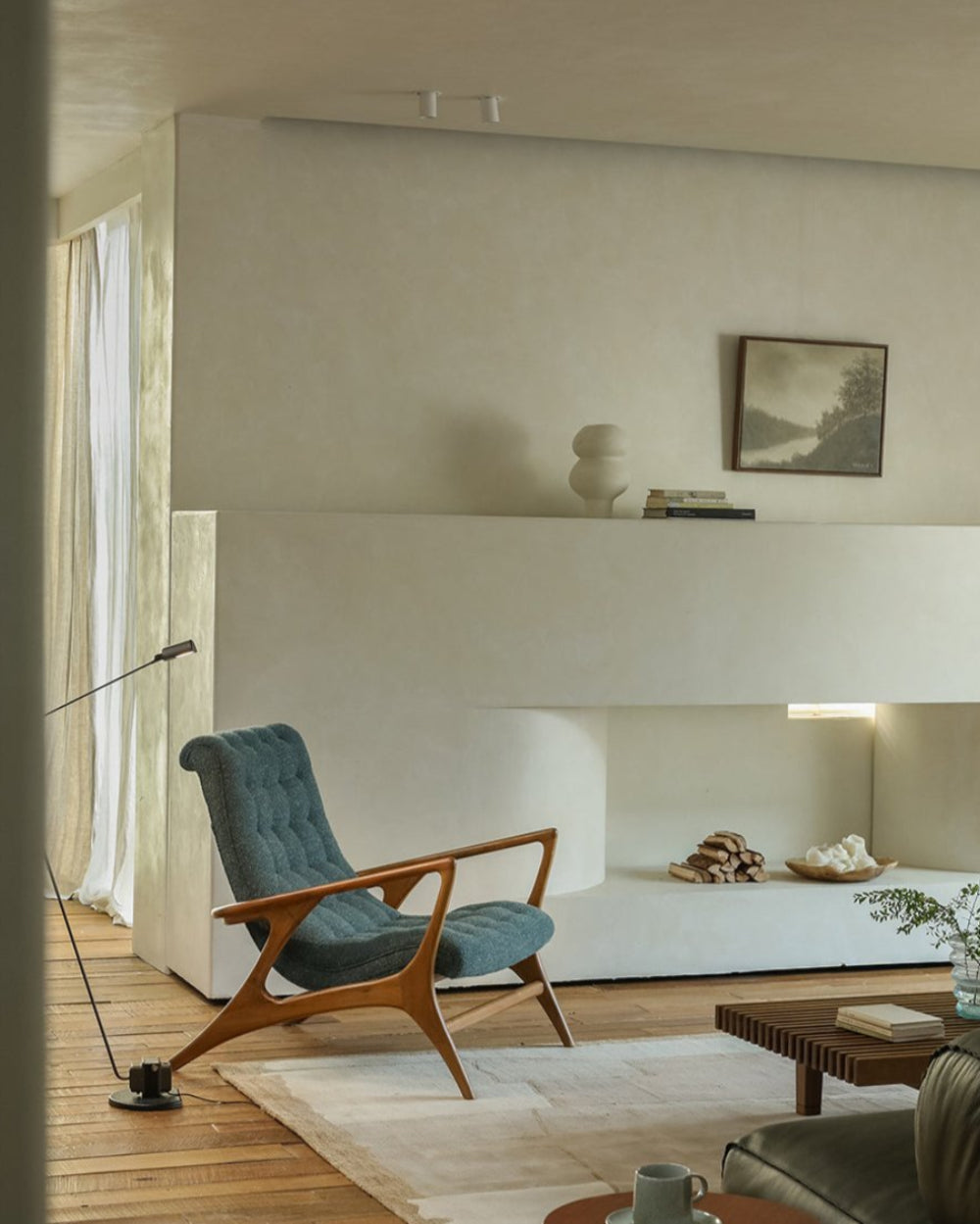 Teal bouclé Kagan Lounge Chair in a modern living room with solid teak wood frame and comfortable design