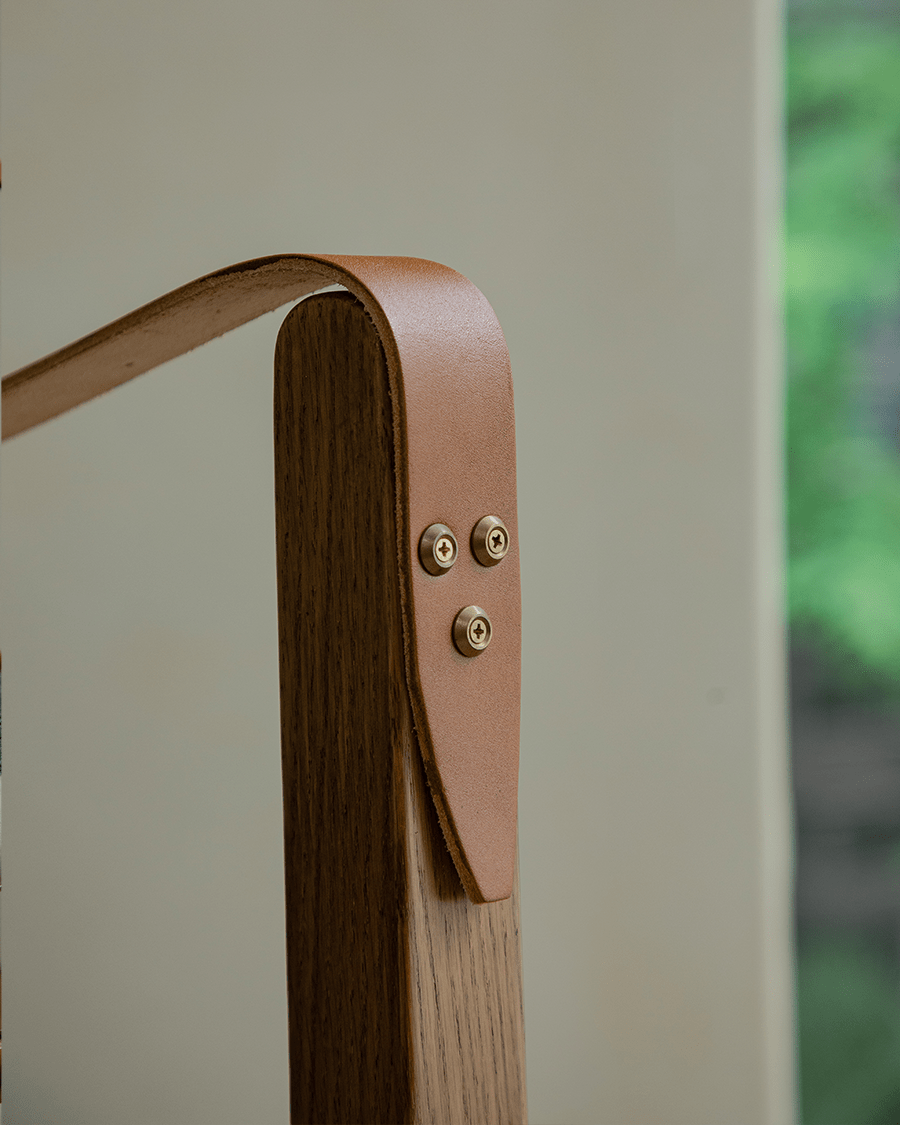 Safari Chair detail: Leather armrest and brass hardware on US Red Oak frame.