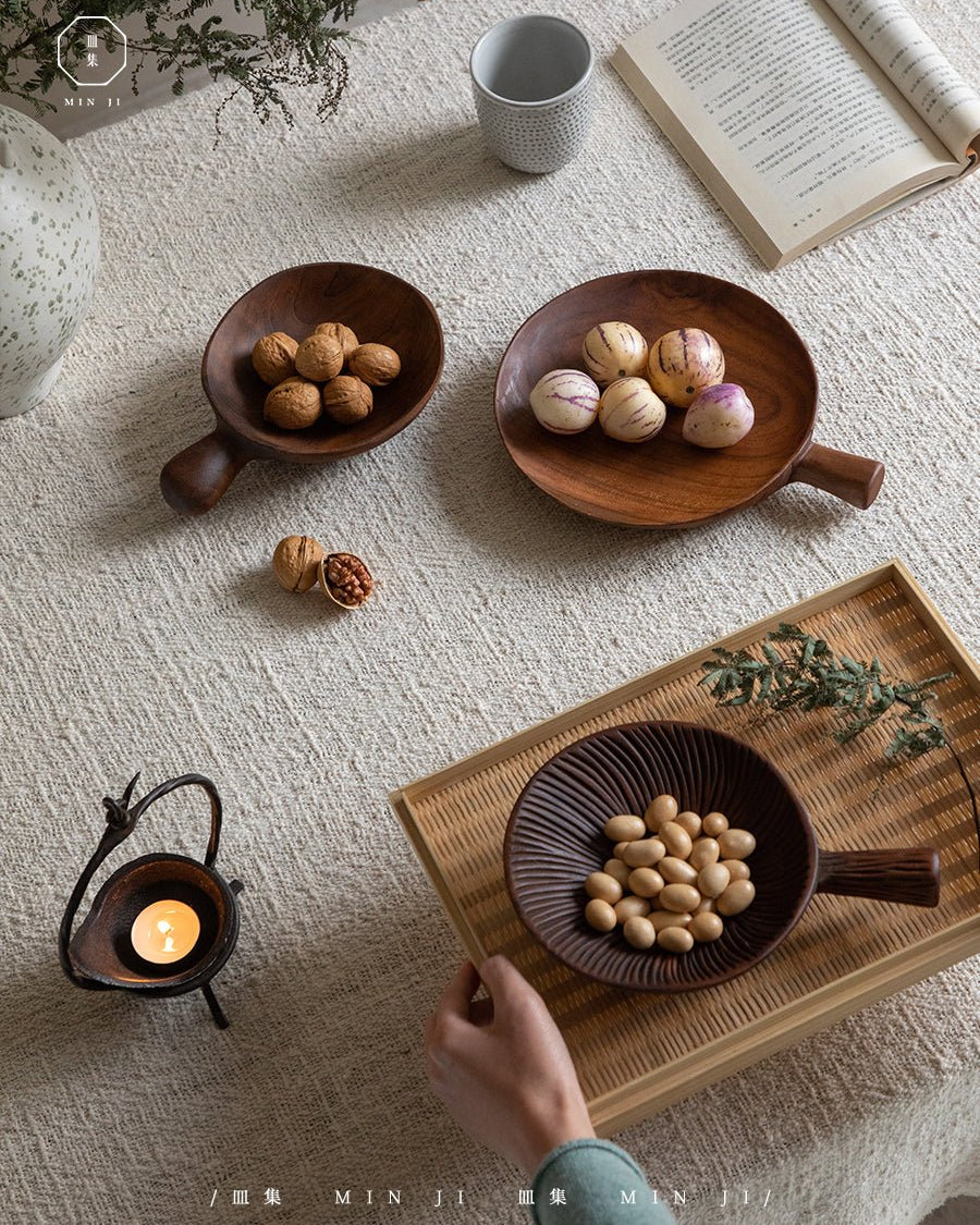 Artisanal teak wood Fany tray with handle, displaying nuts and fruit.