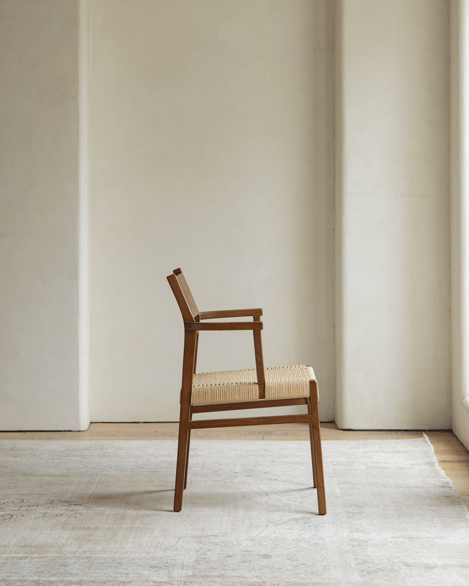 Hug Chair with wooden frame and woven seat, modern design in natural light
