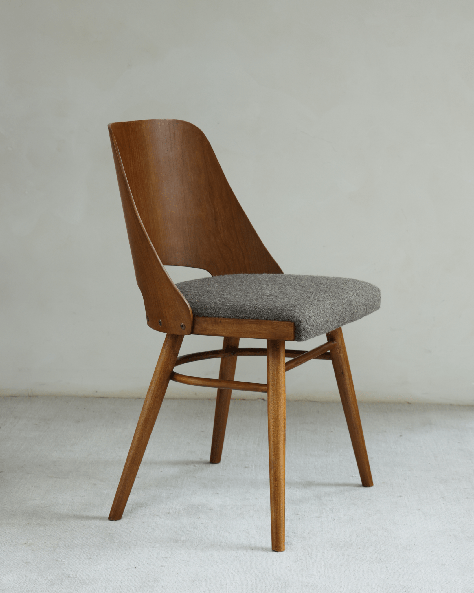 Shell Chair: Mid-century modern design, teak wood frame, and gray loop fabric seat
