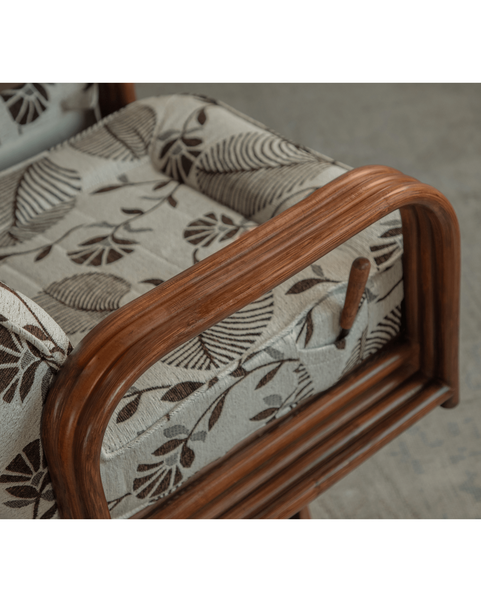 Willow rattan chair arm detail with floral patterned cushion and Indonesian rattan frame, modern comfort