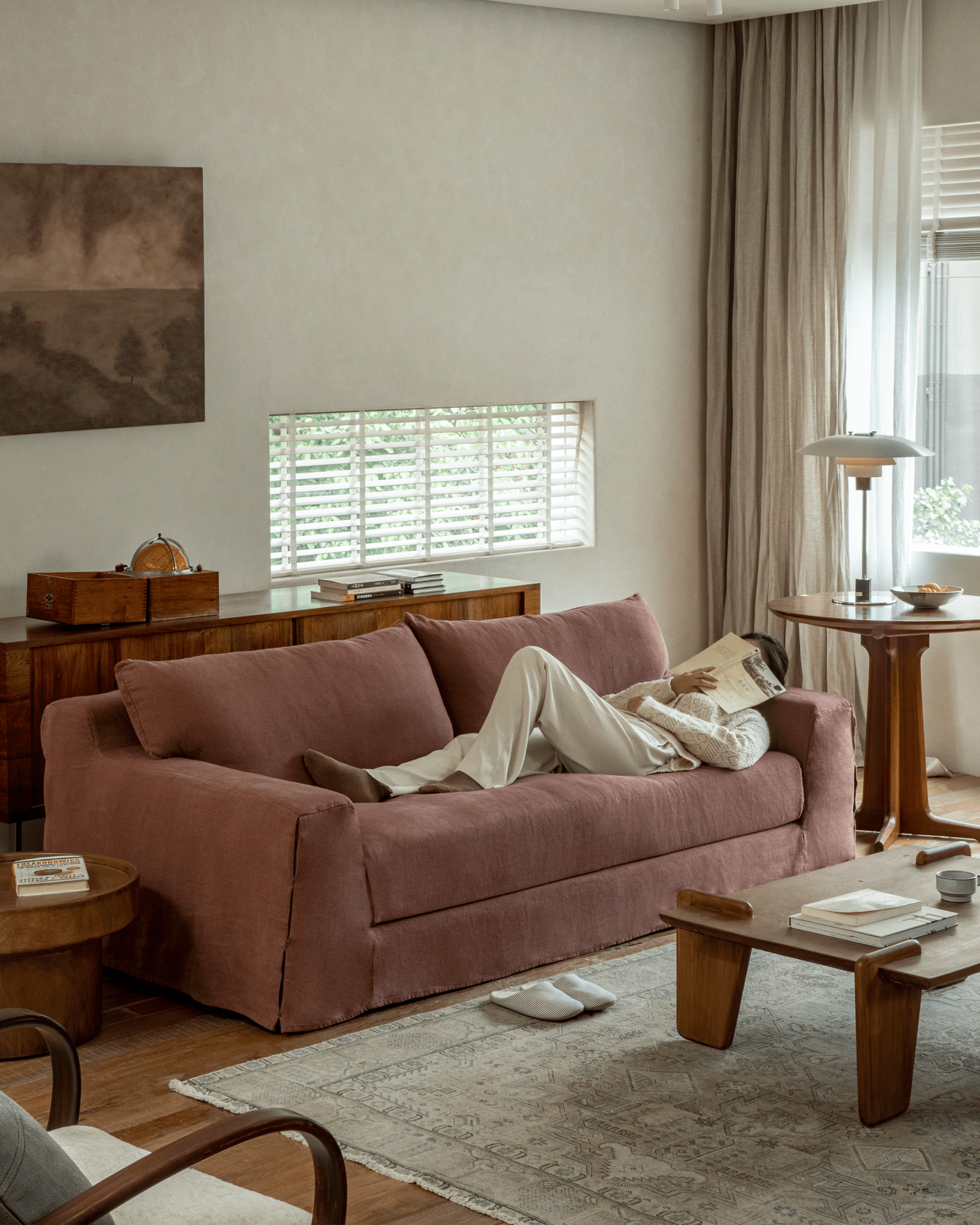 Terracotta Guni Linen Sofa with person relaxing and reading, showcasing linen fabric and cozy design