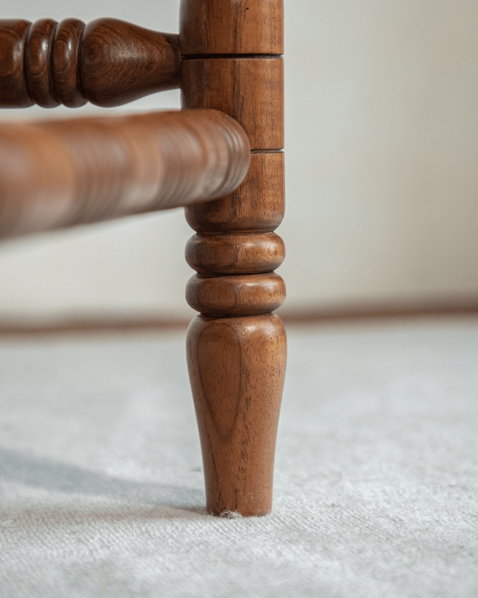 Bobbin Corner Chair detail: Indonesian Teak wooden leg, French Vintage design, showing the crafted details.