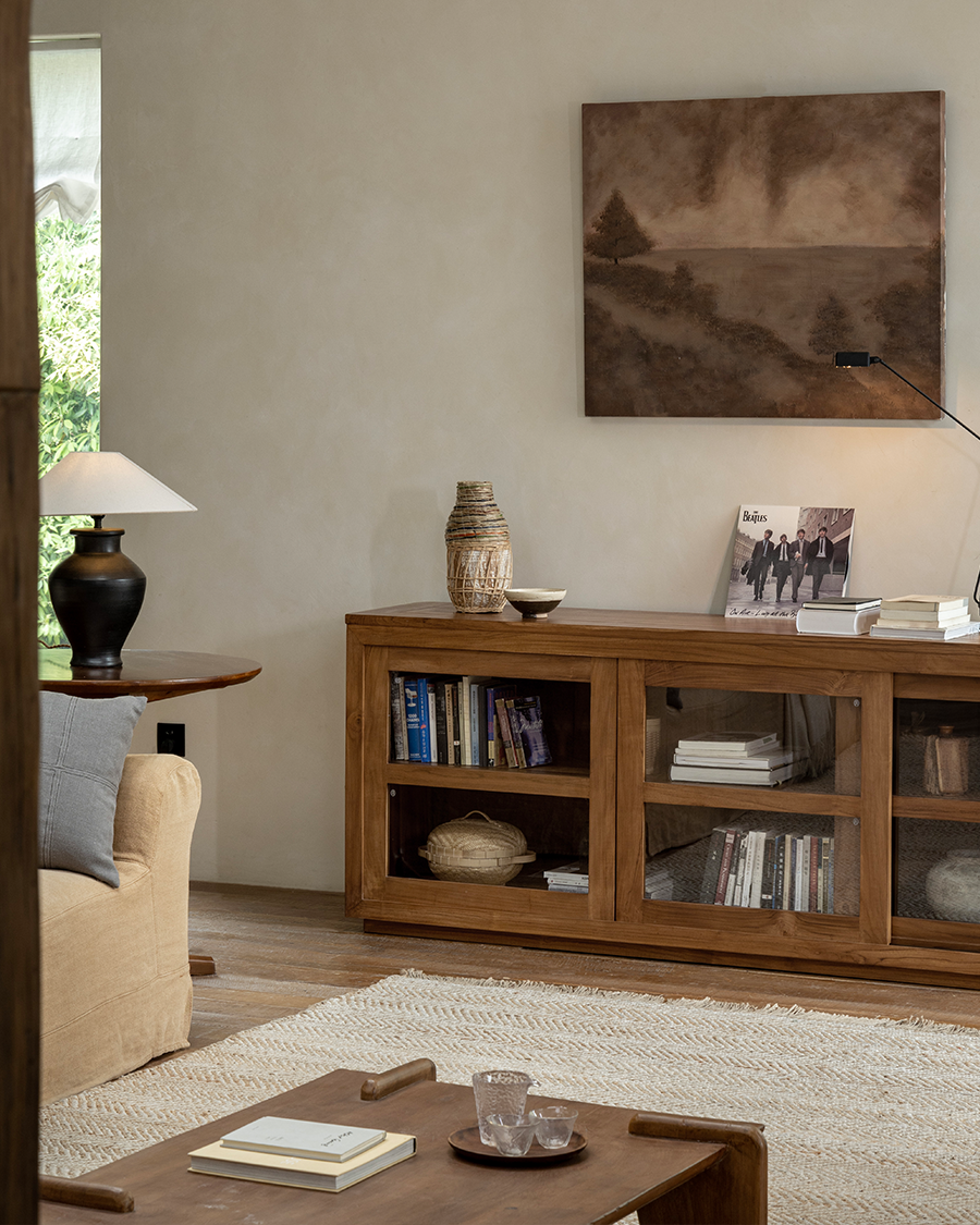 Teak wood glass front bookcase in a stylish living room, perfect for storage and display.