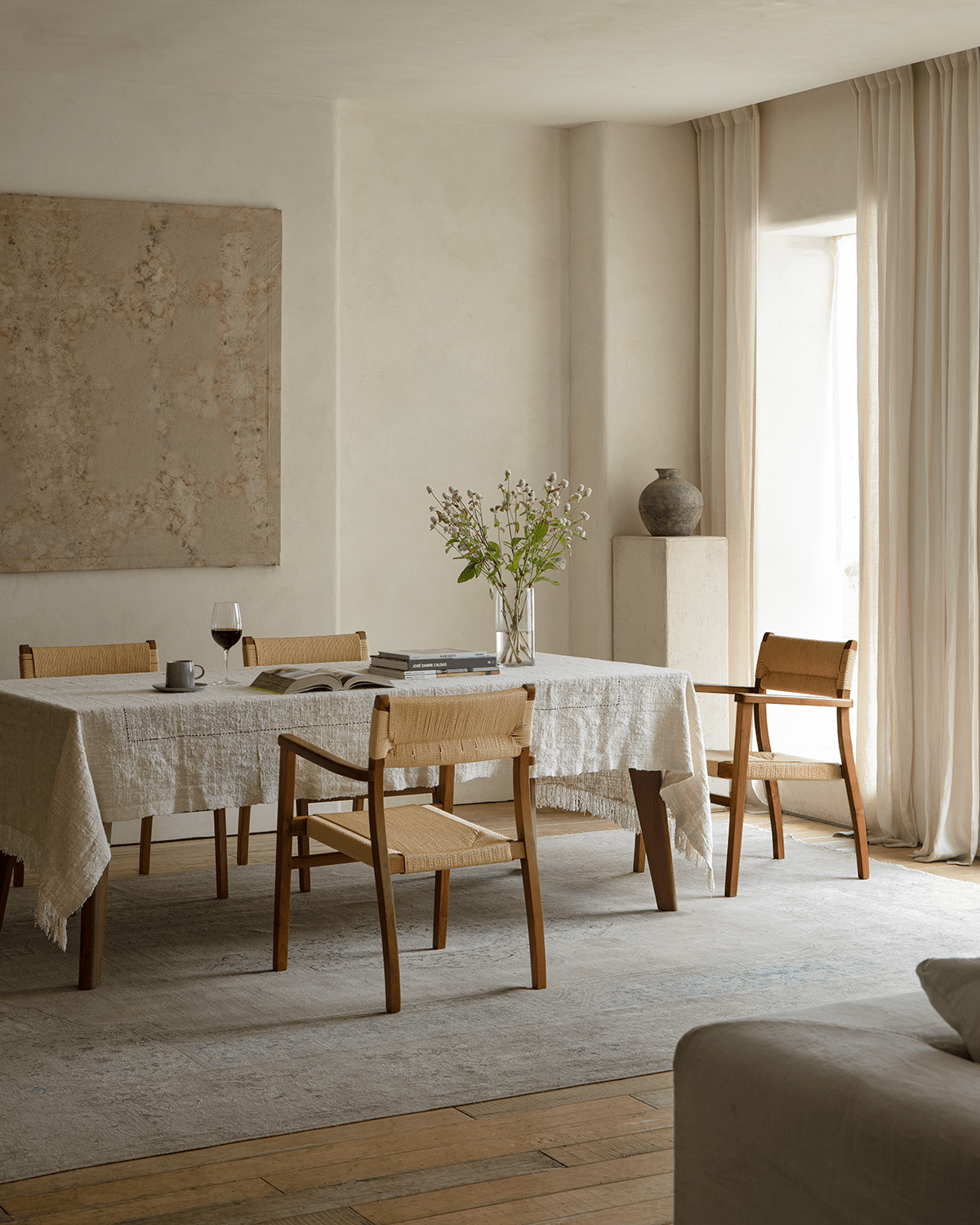 Reed Chair in a dining room setting with teak frame and woven seat, offering stylish and comfortable seating.