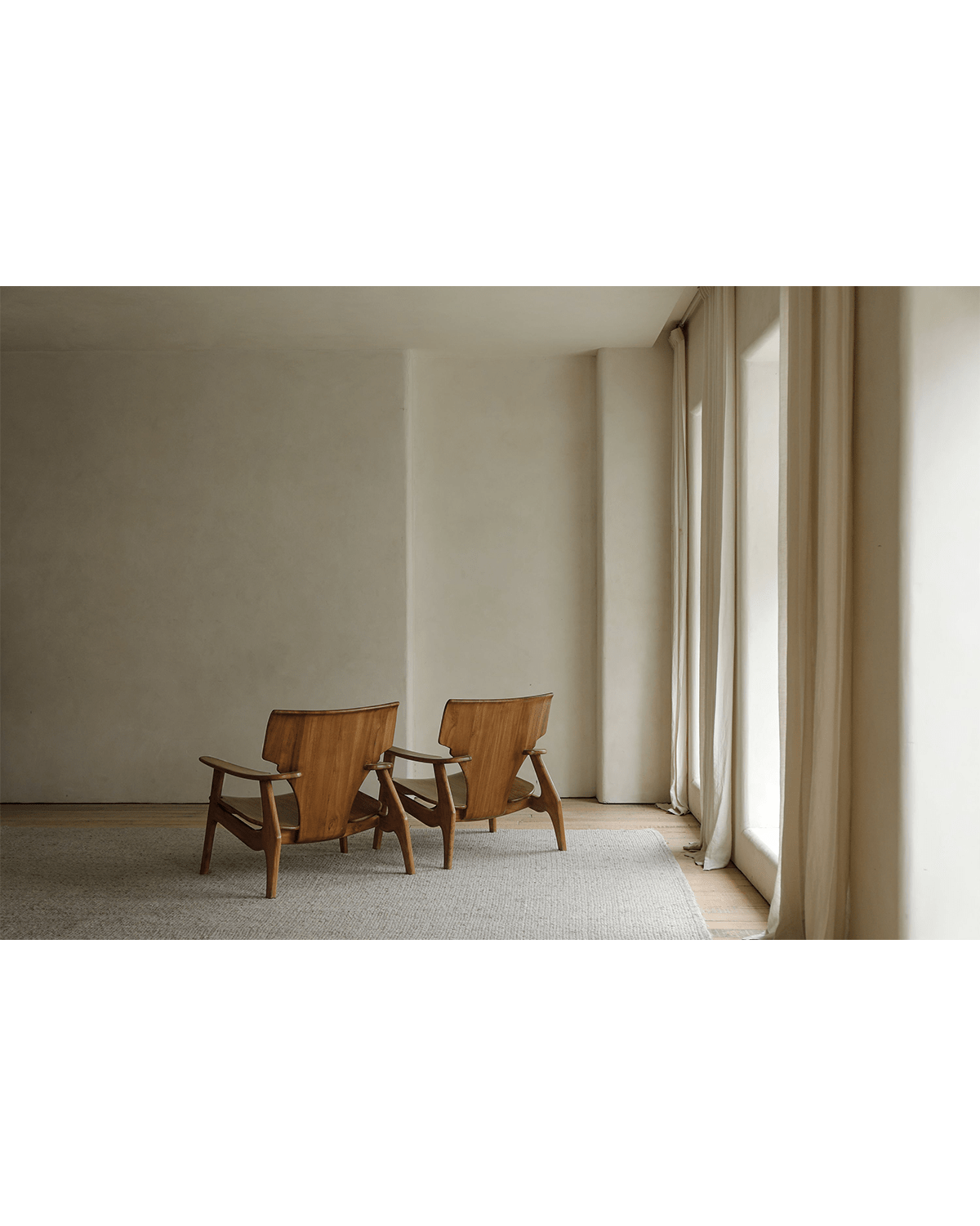 Wooden Zen armchairs in minimalist living room, ergonomic design for ultimate comfort and relaxation, spacious seating.