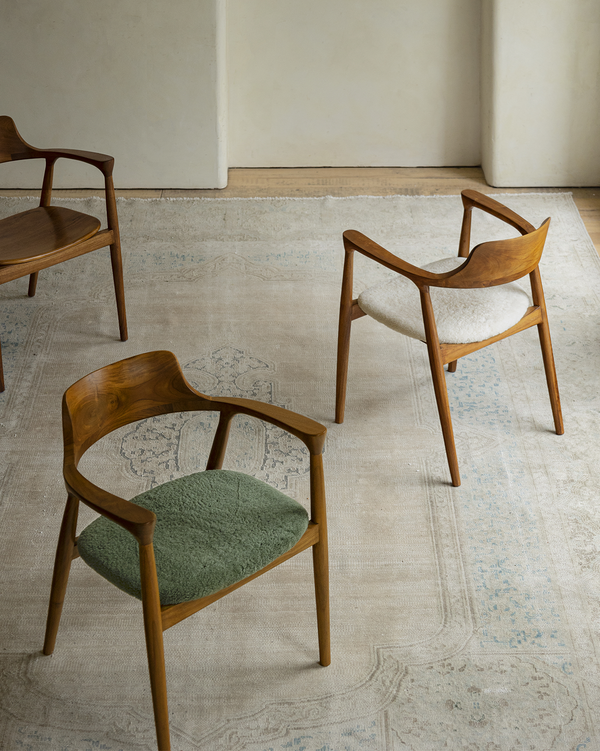 Hiroshima Chair collection, showcasing solid wood frame armchairs with green, white and brown seats for modern living spaces
