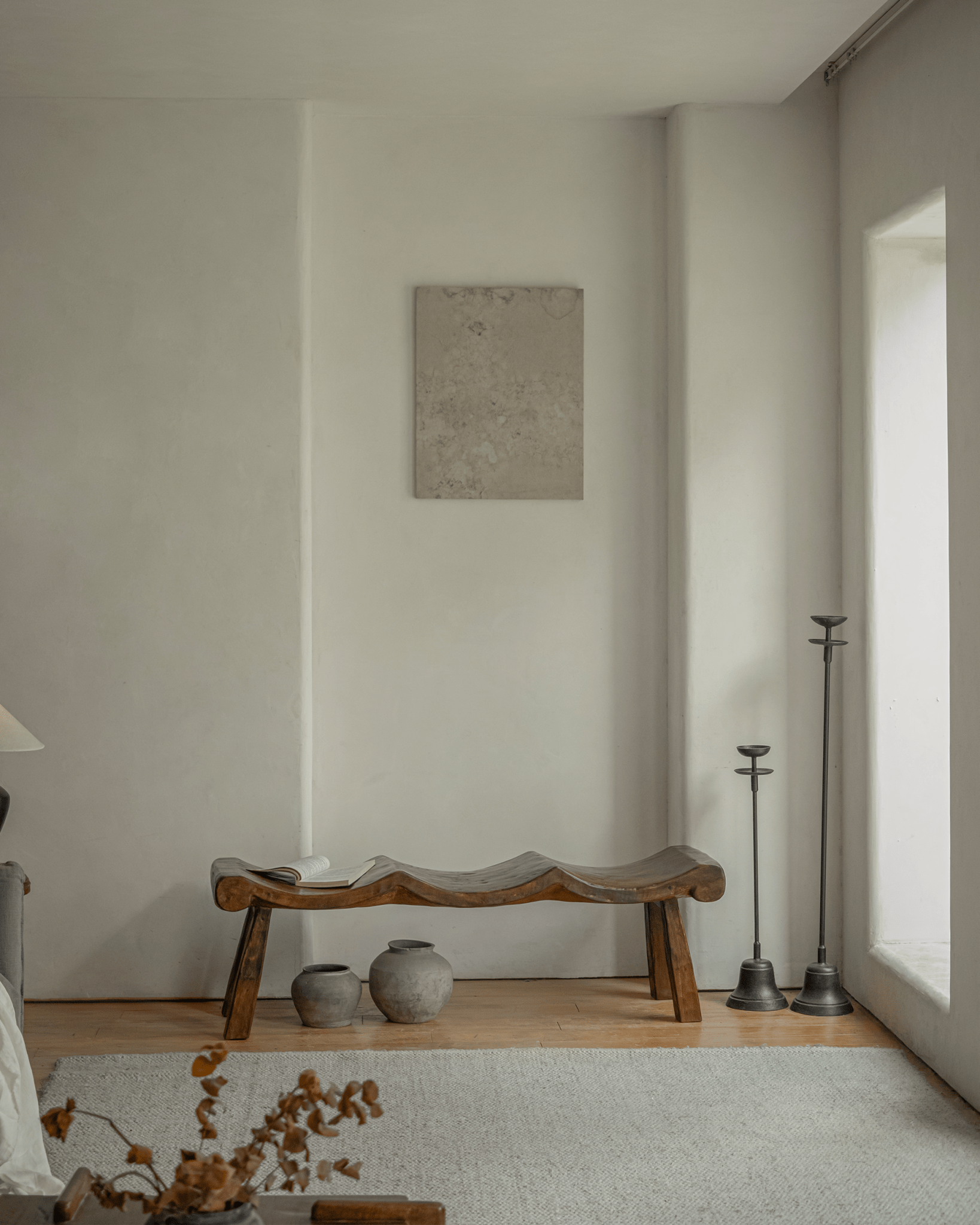 Tildes Bench in a minimalist interior. Carved solid wood bench with wave-like seat, brown color, and sturdy legs.