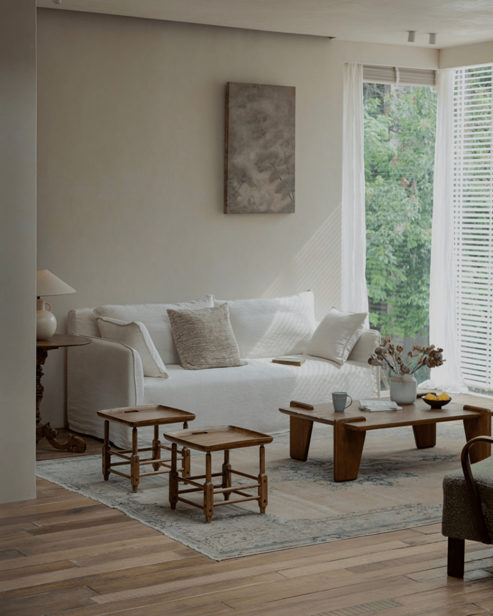 Modern interior with Magrini stools, white sofa, and wooden furniture, showcasing zebrawood details and natural light.