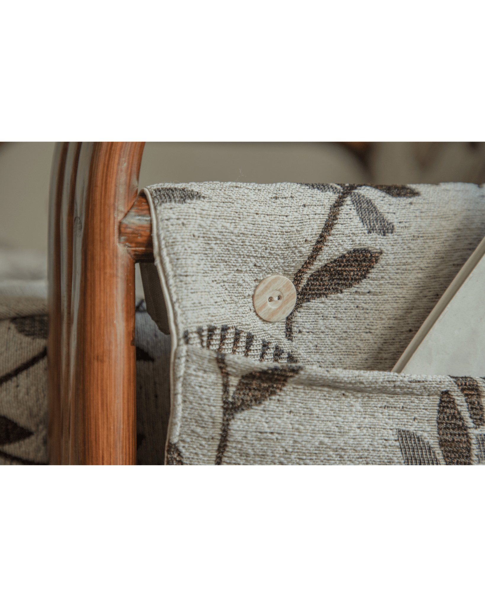Willow Rattan Chair detail, floral leaf cushion, wooden button, Indonesian rattan frame.