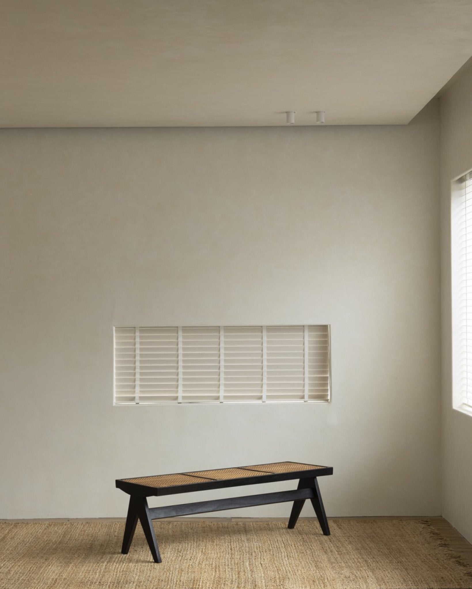 Chandigarh bench in a minimalist interior with natural rattan and teak wood, mid-century design